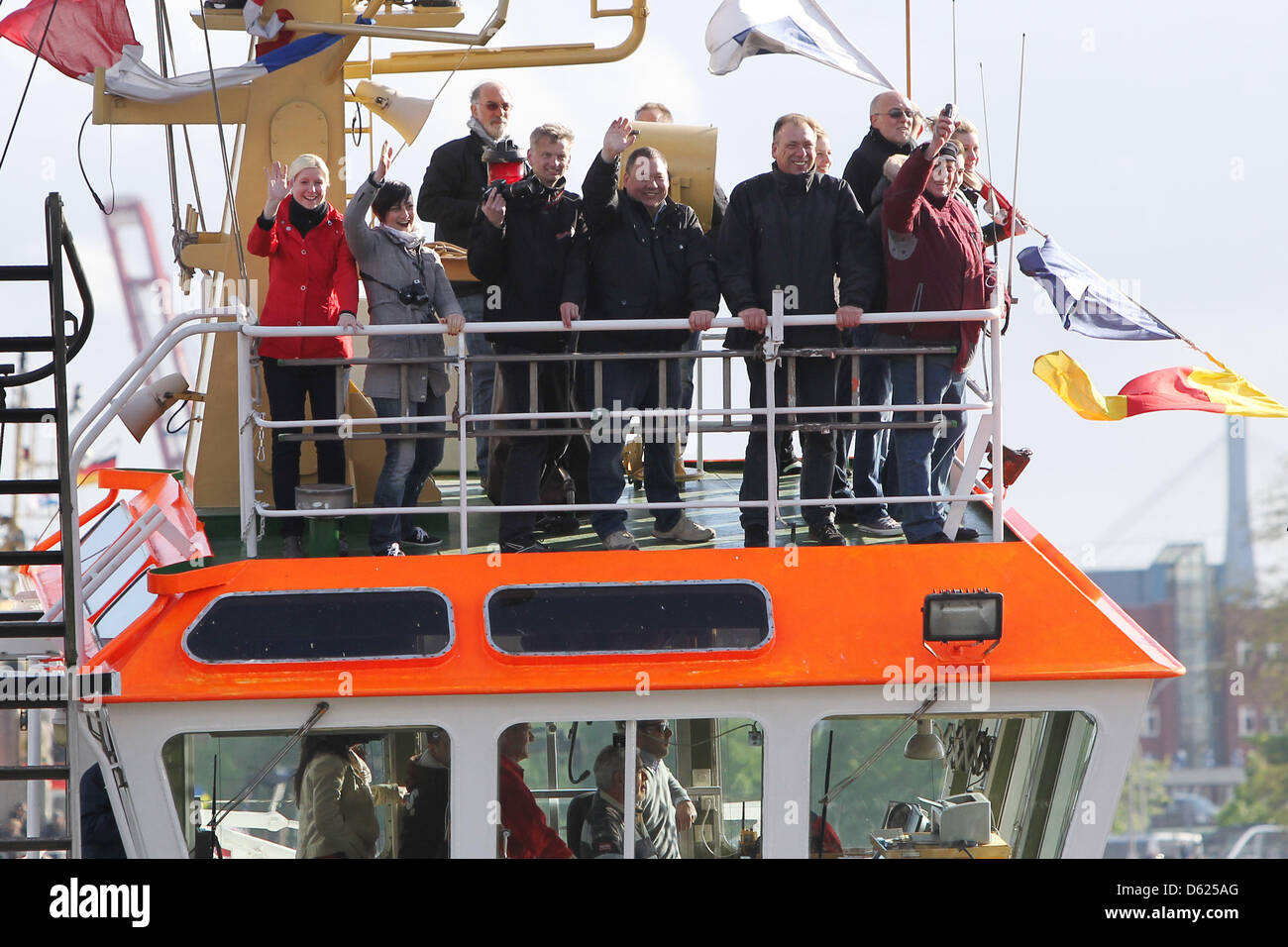 Passeggeri onde da un rimorchiatore guidando lungo il porto durante il cosiddetto "tug ballet" al più grande porto del mondo festival presso il porto di Amburgo, Germania, 12 maggio 2012. Thw 823rd del porto di Amburgo anniversario è celebrato tra 11-13 maggio 2012 ad Amburgo. Foto: MALTE CRISTIANI Foto Stock