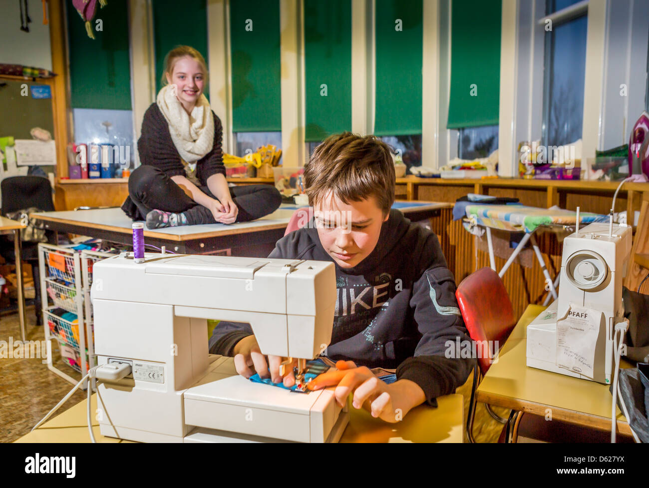 Ragazzo giovane imparare a cucire a scuola, Reykjavik, Islanda Foto Stock