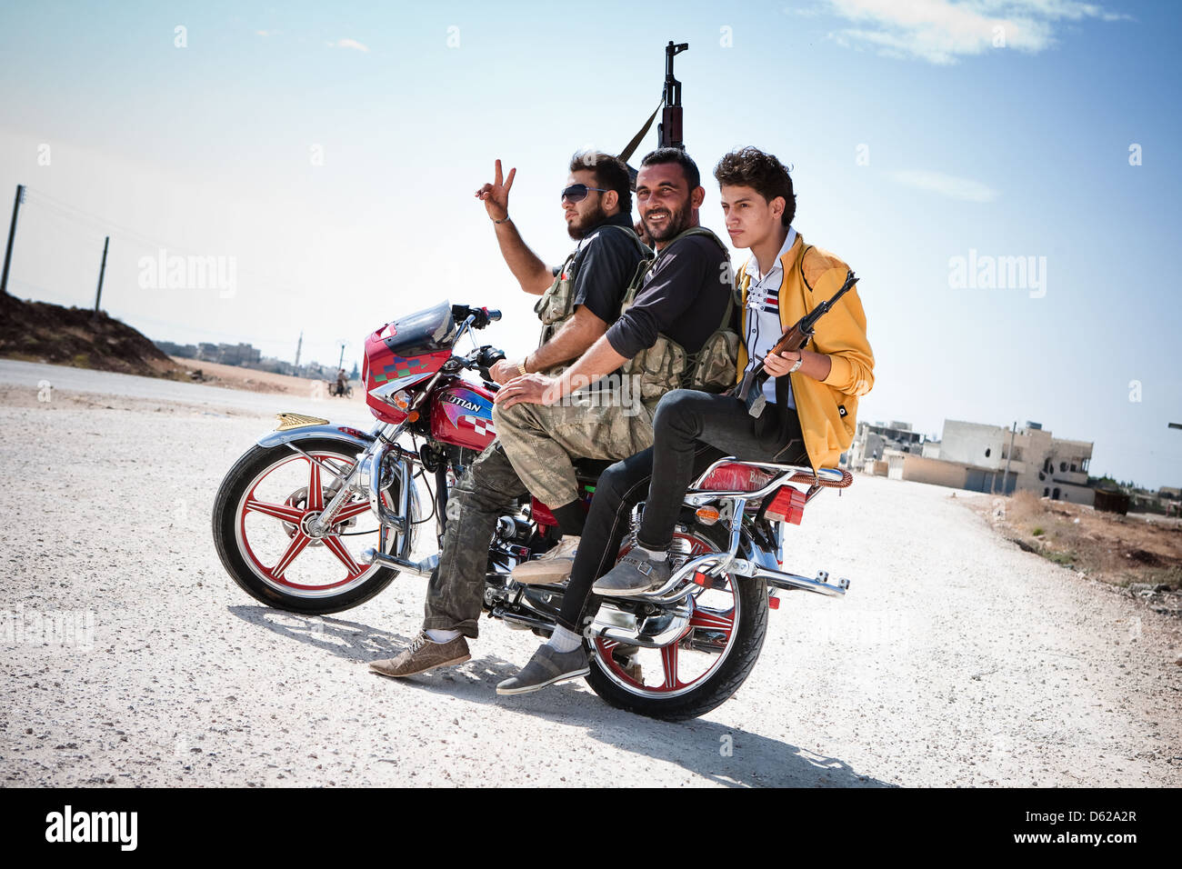 Azaz, Siria. Tre combattenti FSA pongono sul retro di una motocicletta. Foto Stock