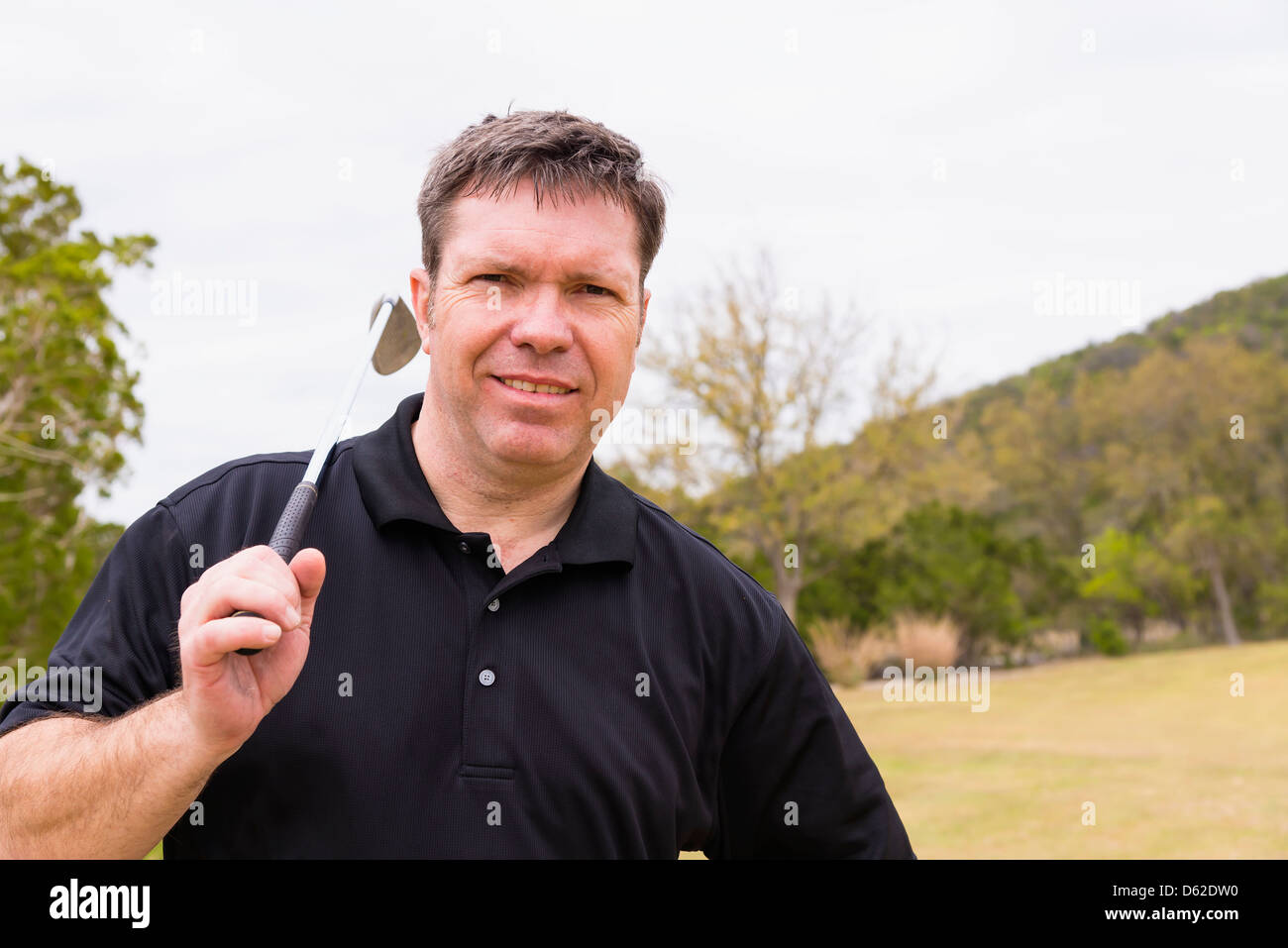 Di mezza età Caucasianman di 46 anni con il club di ferro su un campo da golf Foto Stock