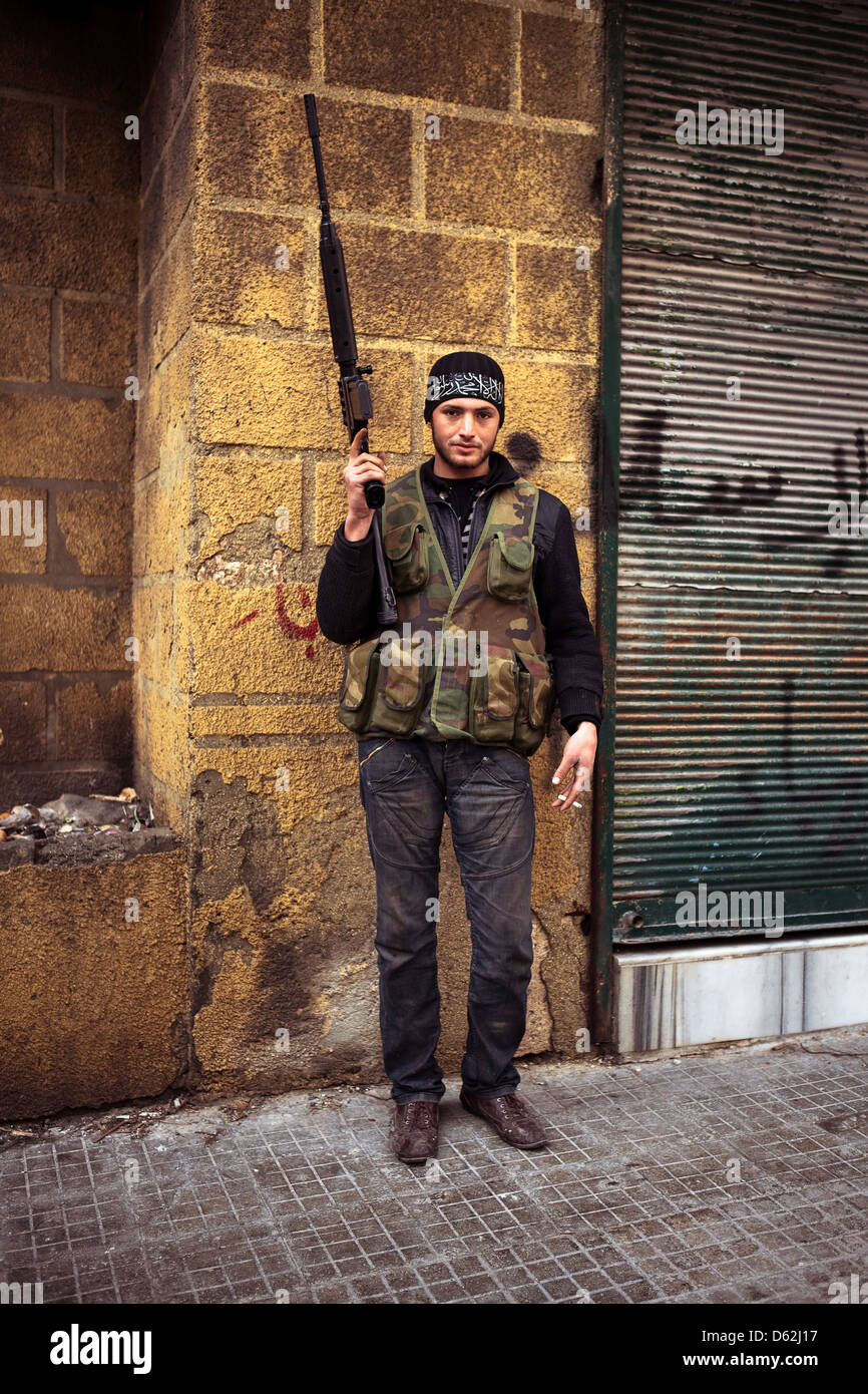 Aleppo, Siria. Un lottatore da FSA pone contro una parete di colore giallo. Foto Stock