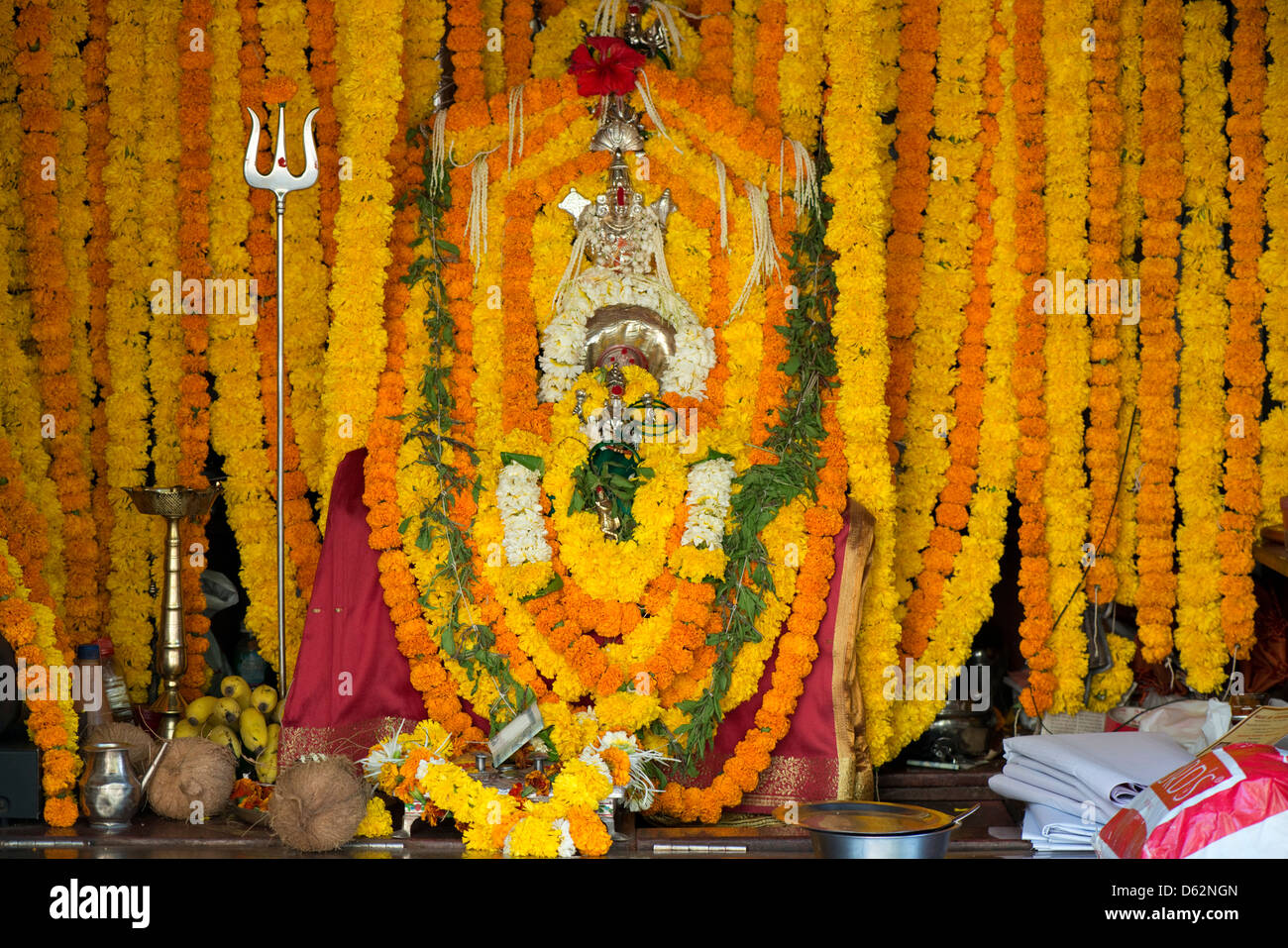 Una massa di fiori adorna la divinità Indù Durga a un tempio nel quartiere Khardunda di Mumbai, Maharastra, India Foto Stock