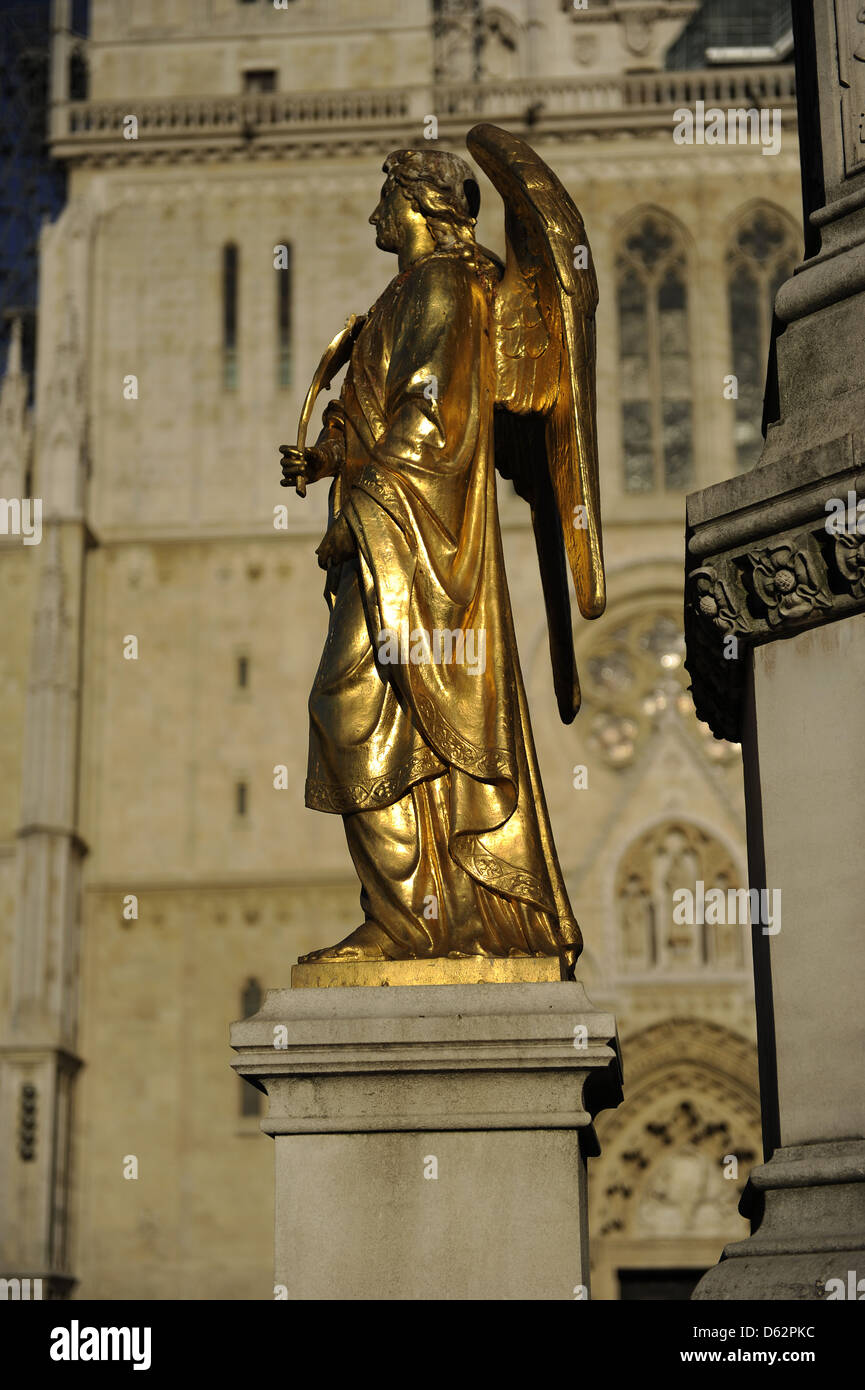 La Croazia. Zagabria. Santa Maria di colonna con angeli e fontana. Uno dei quattro angeli dorati sul piedistallo. Kaptol Square. Foto Stock