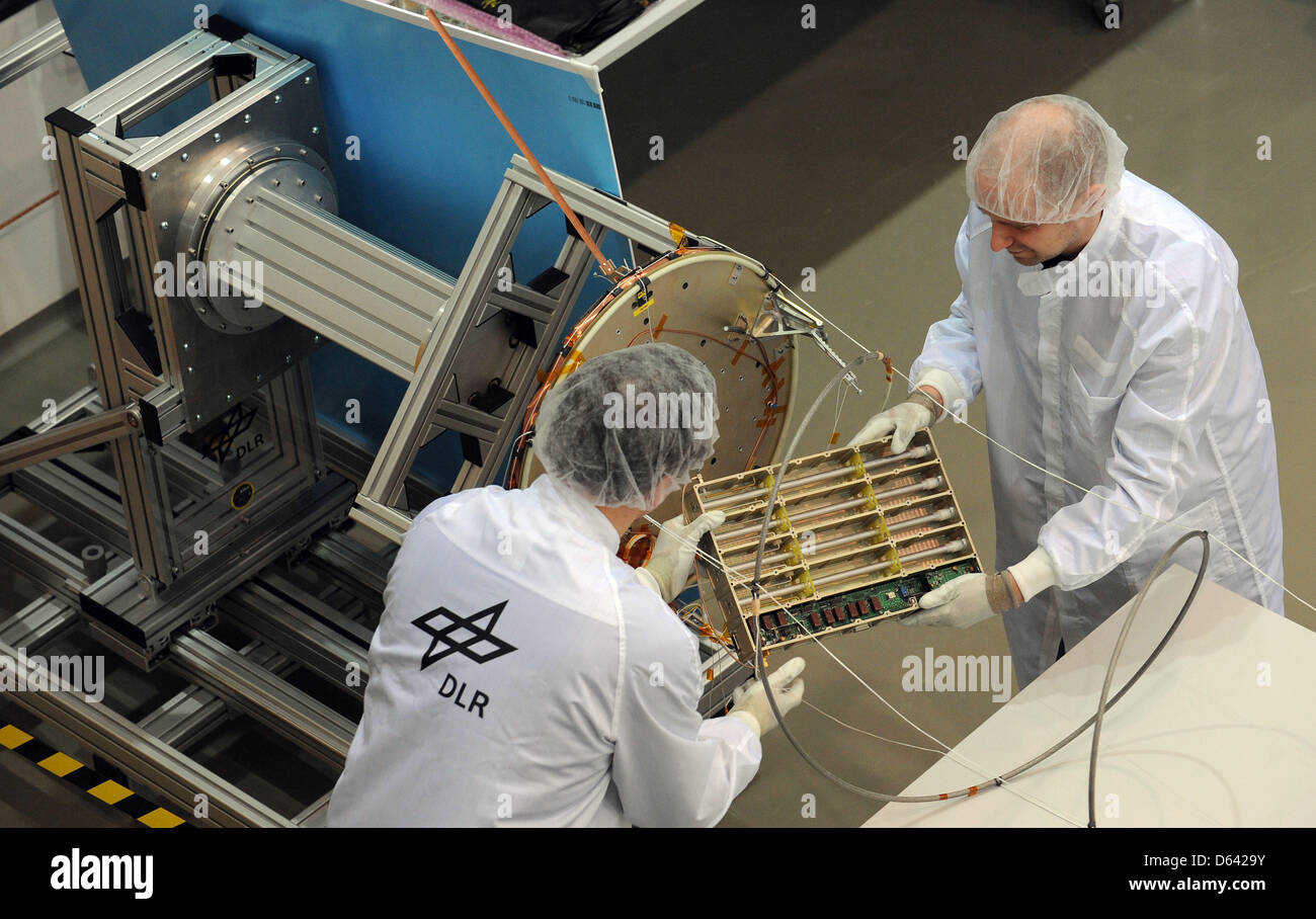 Ingegnere aerospaziale Martin Drobczyk (R) e Falk Nohka del Centro aerospaziale tedesco (DLR) funziona su un componente della AI Satellite in DLR cleanroom di Brema, Germania, 21 marzo 2013. Il satellite di ricerca è destinata a ricevere il sistema di identificazione automatico di segnali e di essere in grado di individuare le navi meglio come satelliti tradizionali. Foto: CARMEN JASPERSEN Foto Stock