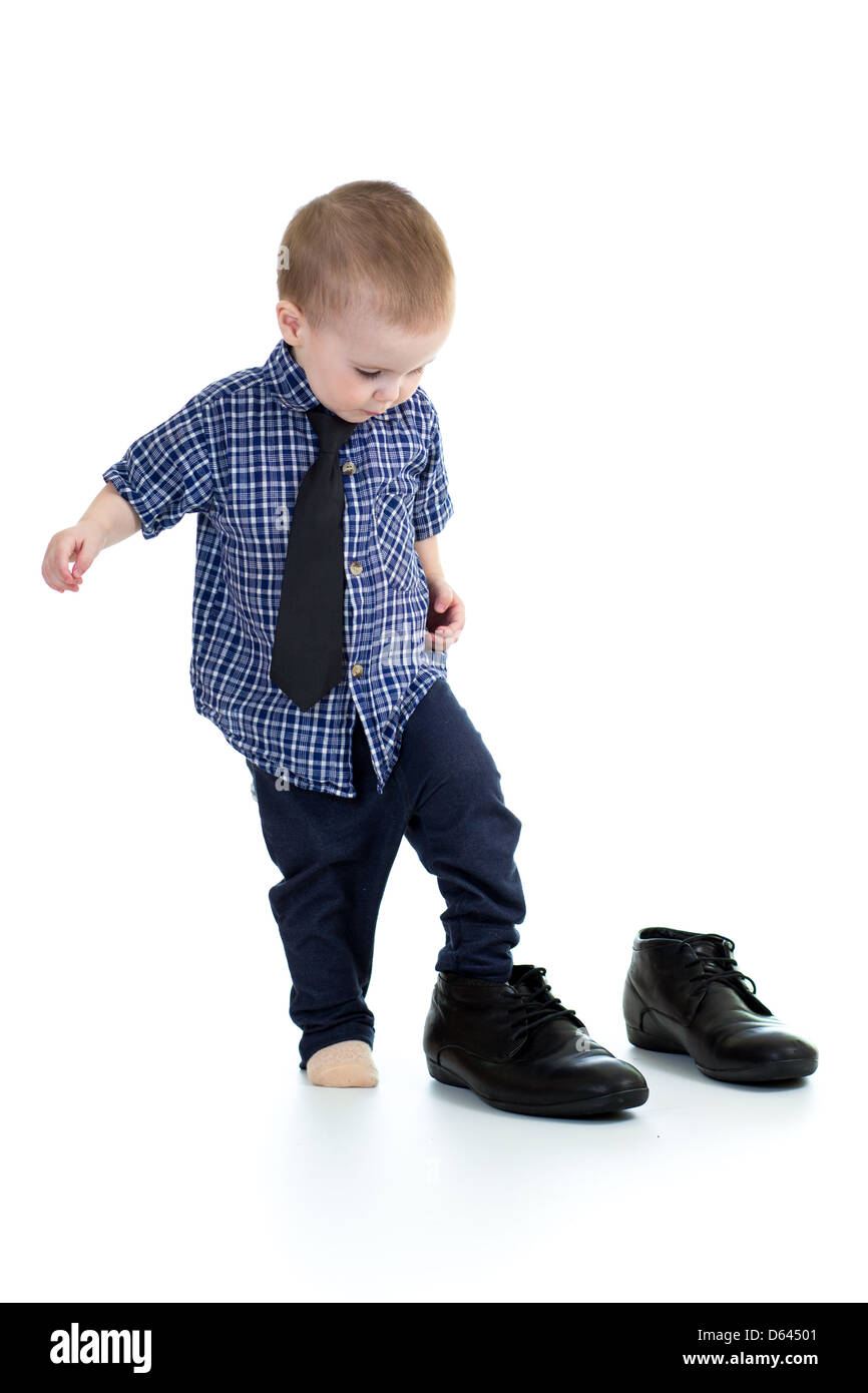 Little Boy cercando sul padre scarpe Foto Stock
