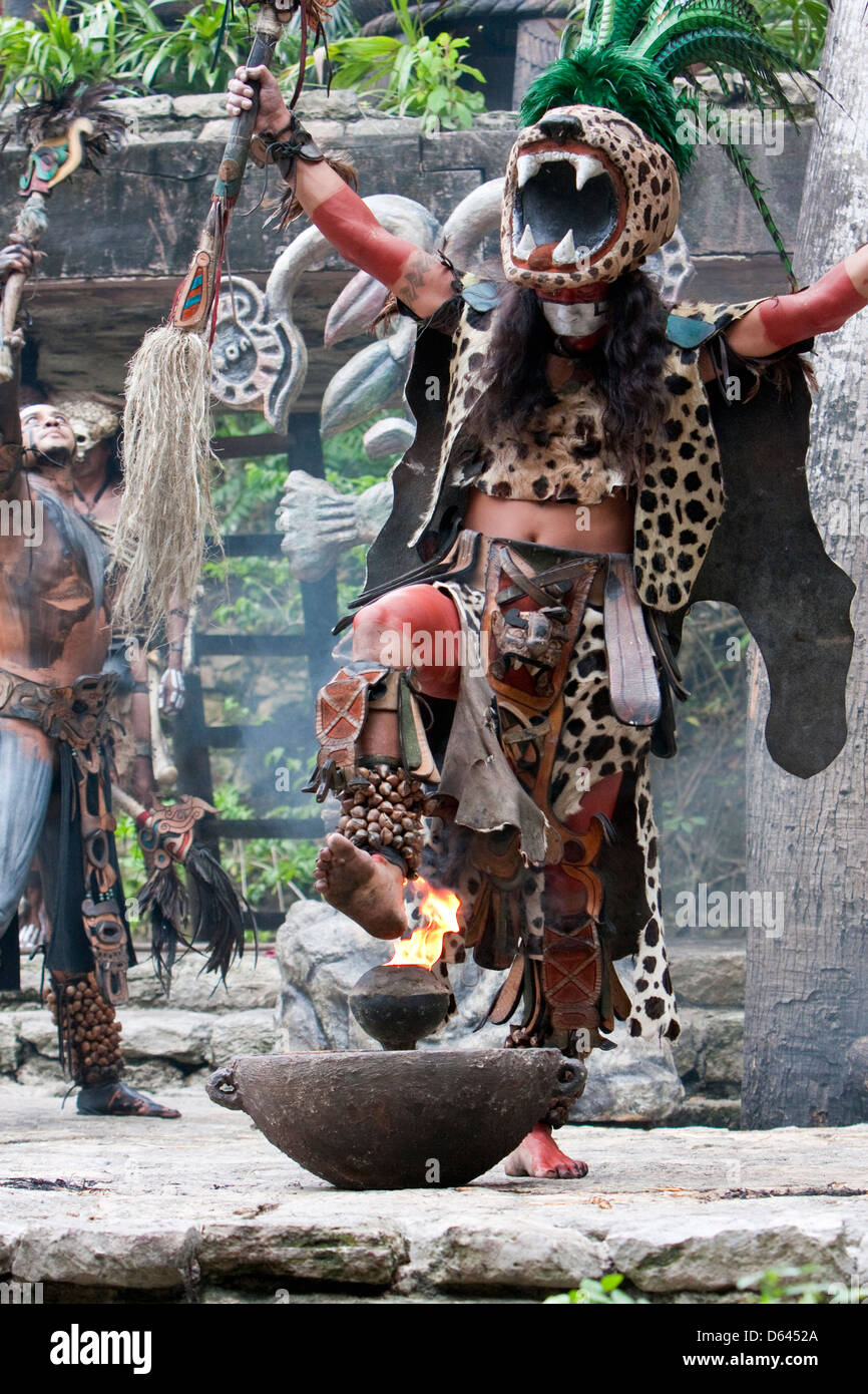 Ballerino Maya in rappresentanza di Ek Balam (Jaguar), un guerriero dio, ponendo il piede sul sacro fuoco. Xcaret, Riviera Maya, Yucatan, Messico. Foto Stock