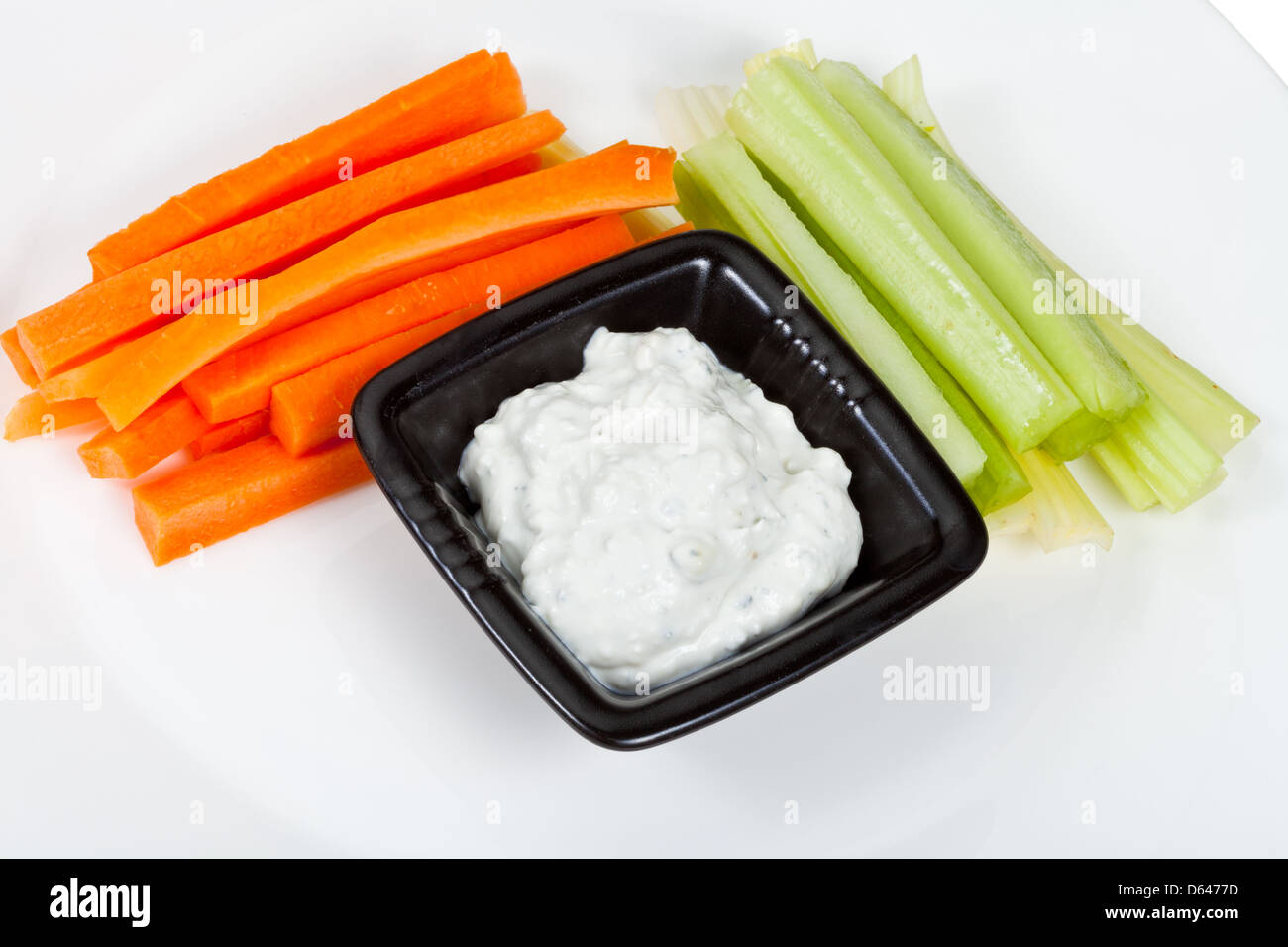 Sedano fresco, la carota con condimento a base di formaggio erborinato sulla piastra bianca Foto Stock