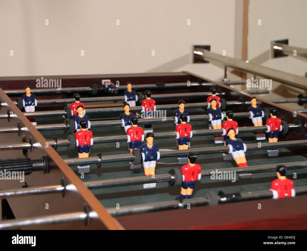 Un biliardino, un gioco popolare spesso trovato nelle case e nelle aree ricreative. Il tavolo ha giocatori e aste allestite per una partita competitiva. Foto Stock