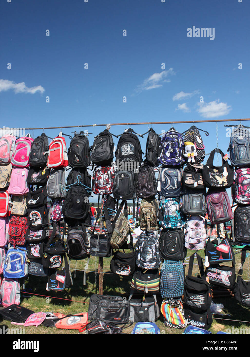 Questa immagine presenta una varietà di zaini dai colori vivaci progettati per l'uso scolastico, che presentano stili e dimensioni diversi. Gli zaini sono resistenti, pratici e adatti per il trasporto di materiale scolastico. Foto Stock