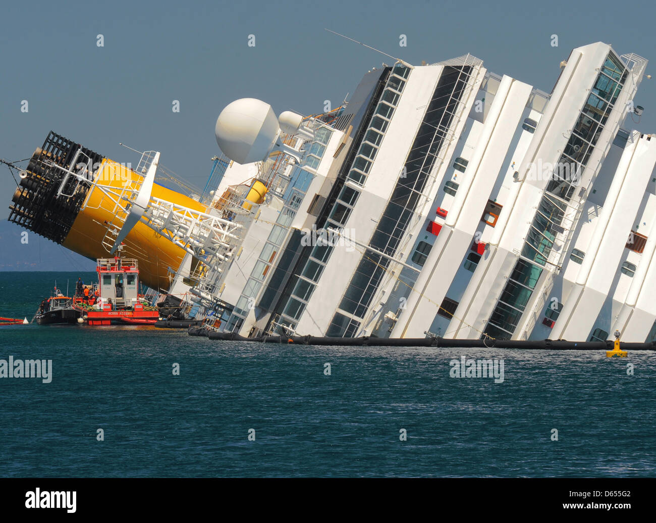 Il rovesciamento Costa Concordia nave da crociera si trova fuori del porto di Isola del Giglio (Isola del Giglio), Italia, 17 maggio 2012. La nave da crociera riposa semi affondata davanti all'Isola del Giglio, dopo aver colpito rocce sottomarine il 13 gennaio 2012. Dopo la "e-alimentando il processo che è stato finalizzato ad evitare fuoriuscite e la contaminazione di uno del Mediterraneo più incontaminate sanctuarie naturale Foto Stock