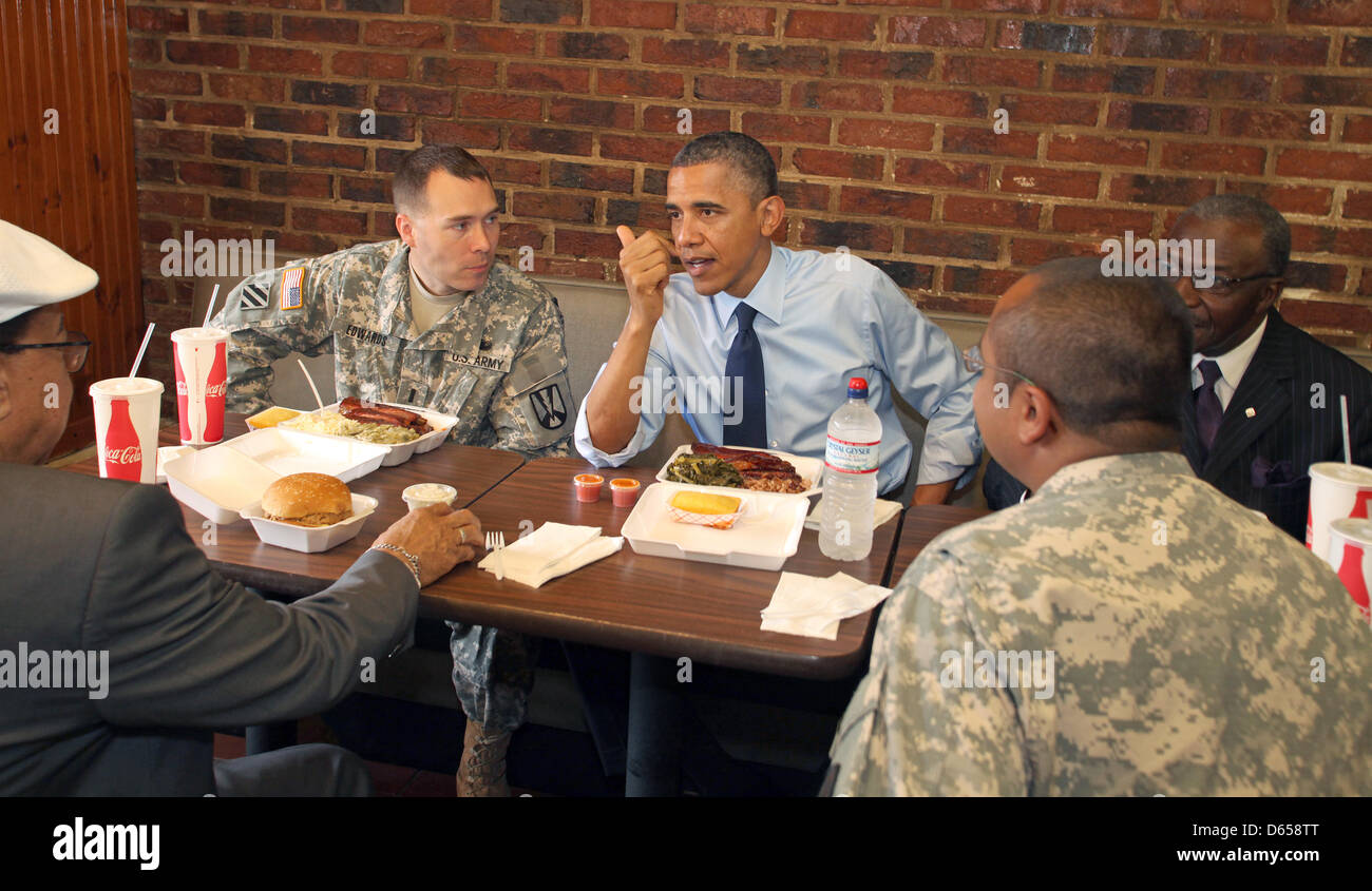 Il Presidente degli Stati Uniti Barack Obama al sacco con due active-servizio i membri delle forze armate e due locali barbieri a Kenny's BBQ sulla Capitol Hill nella celebrazione della Festa del Papà, a Washington D.C. il Mercoledì, 13 giugno 2012. Fiancheggianti il presidente sono primo tenente William (Bill) Edwards, sinistra e barbiere Otis grande "O' Gamble. Di fronte al presidente sono Nurney Mason di Mason's Foto Stock