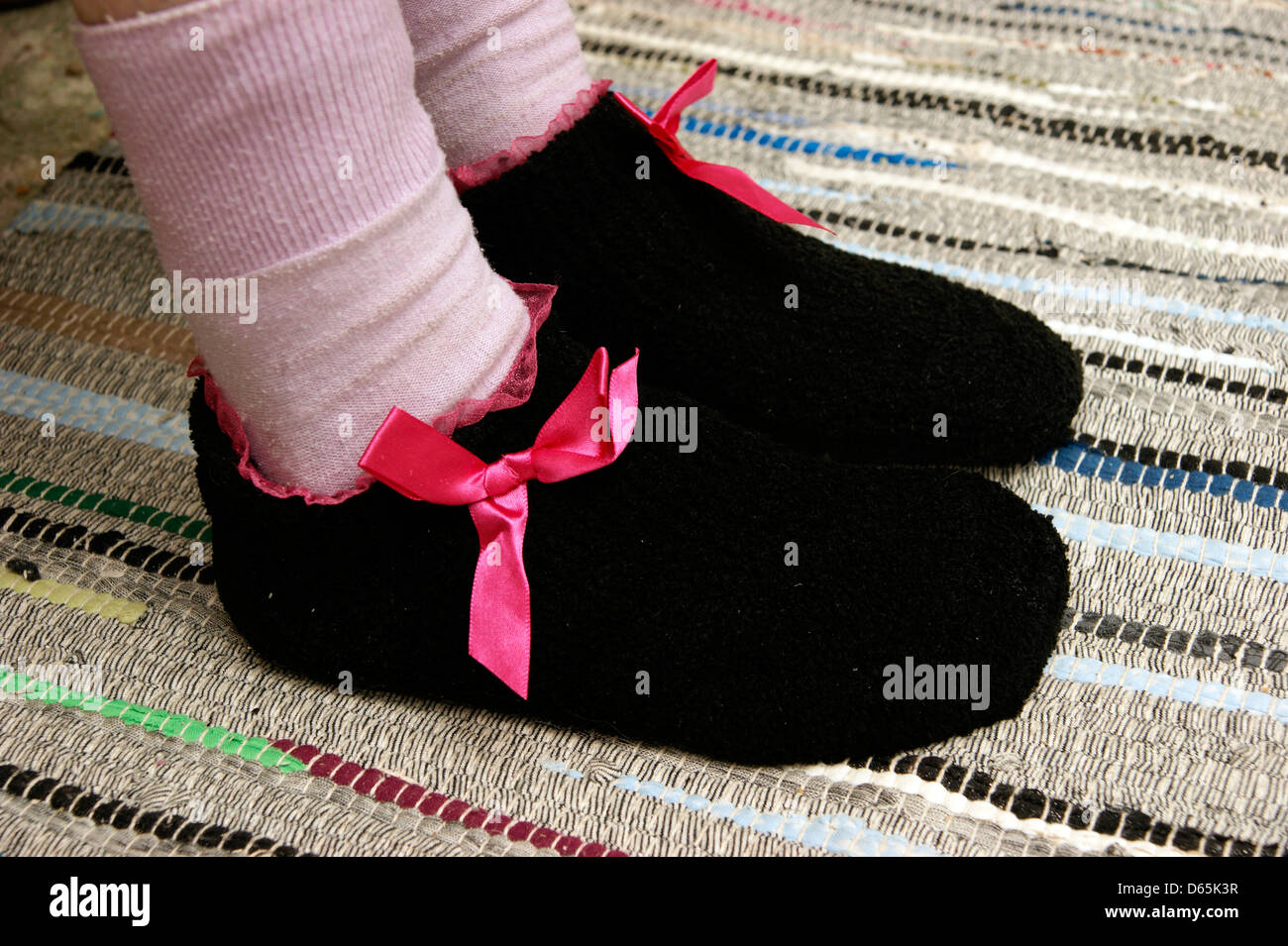 Donna anziana di indossare i calzini e pantofole in maglia per mantenere caldo e accogliente in inverno Foto Stock
