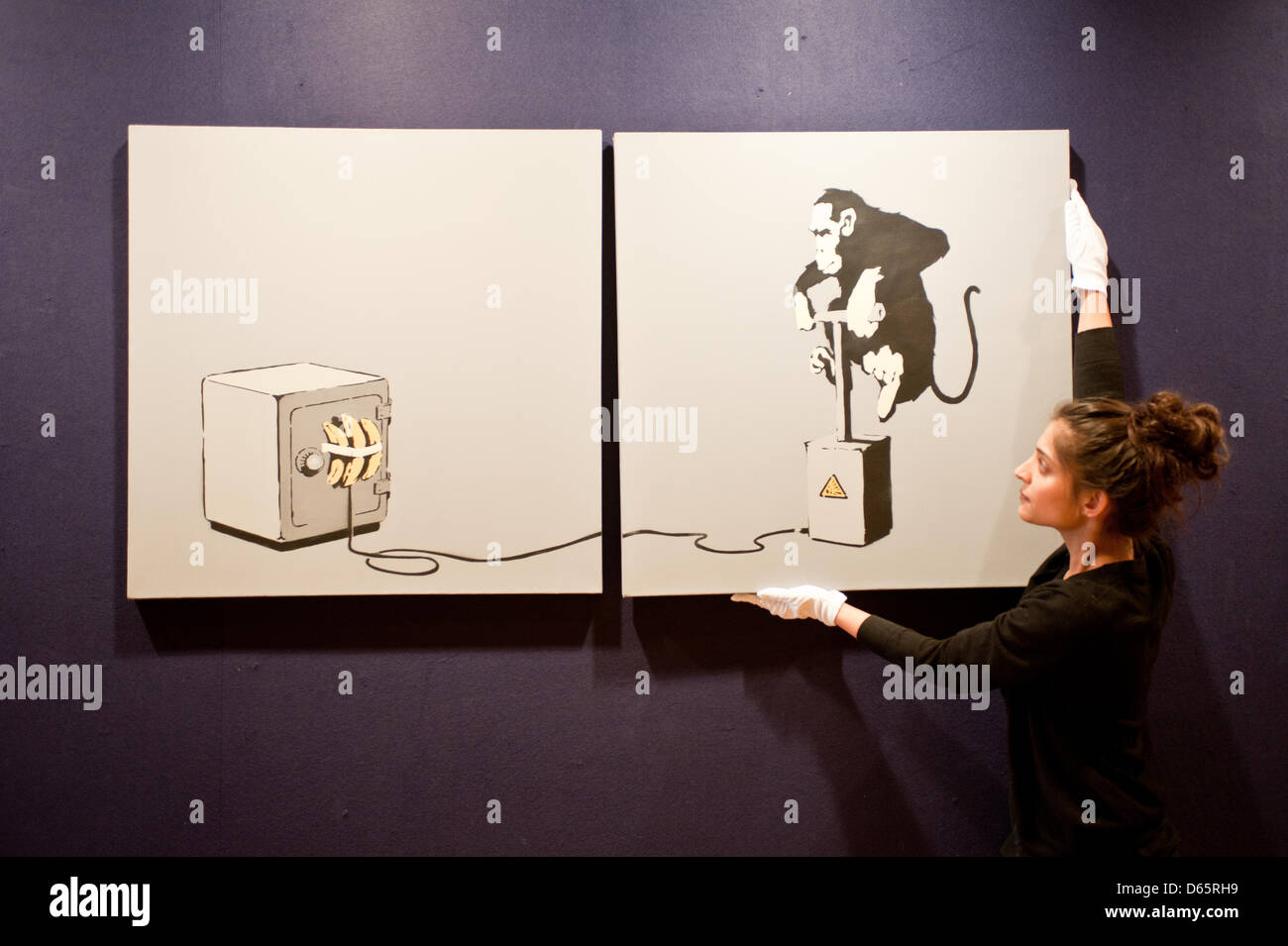 Londra, Regno Unito. Il 12 aprile 2013. Un assistente vendite detiene un dittico tela intitolata "detonatore di scimmia" da Banksy durante il 'Arte Urbana' anteprima di aste Bonhams a. Il lavoro viene visualizzato il suo tipico senso dell umorismo surrealista. La misurazione 152 da 76 cm., questo dipinto porta ad una stima di £ 70,000-100,000. Credito: Piero Cruciatti / Alamy Live News Foto Stock
