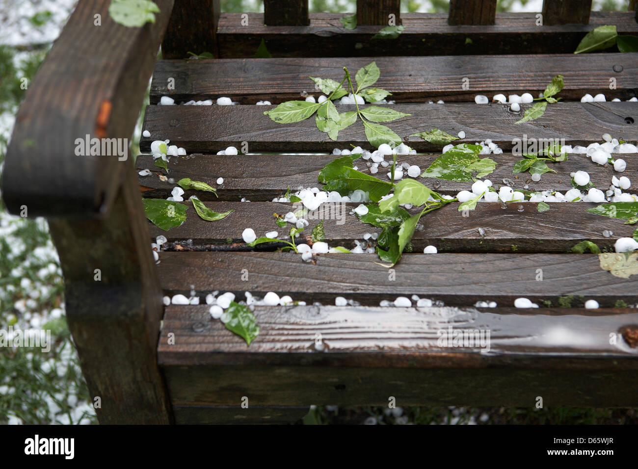 Pietre di grandine sulla panchina da giardino Foto Stock
