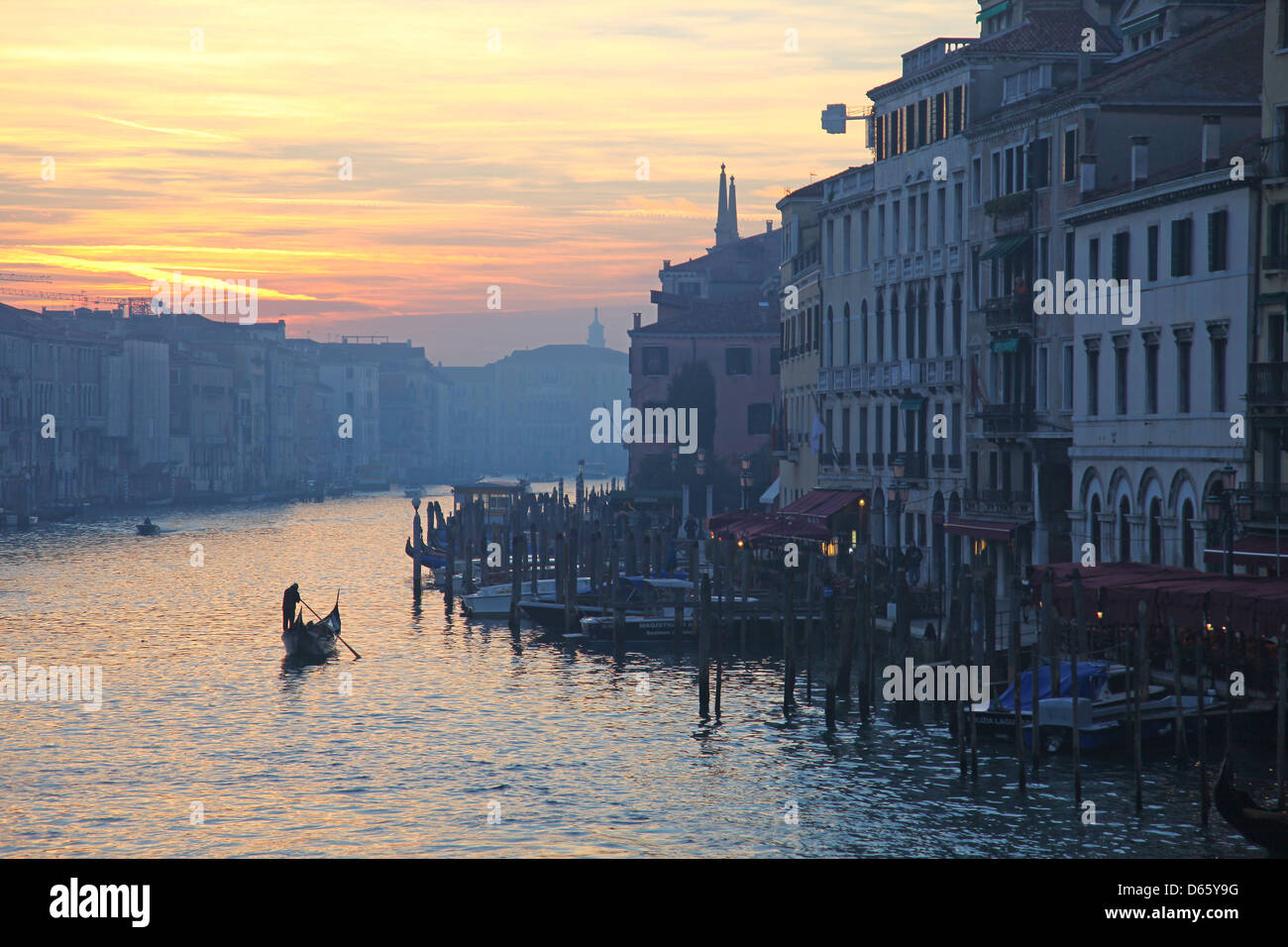 Gondolieri sul Canal Grande serata con il cielo rosso del tramonto a Venezia Italia Foto Stock