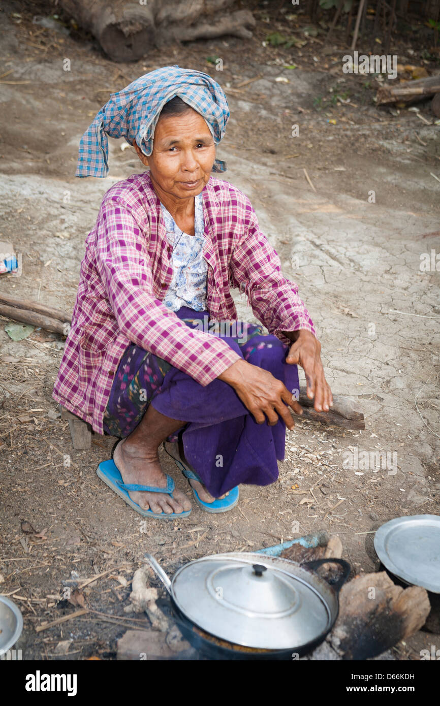 Donna anziana cucinando fuori, Yay Kyi village, Mandalay Myanmar (Birmania) Foto Stock
