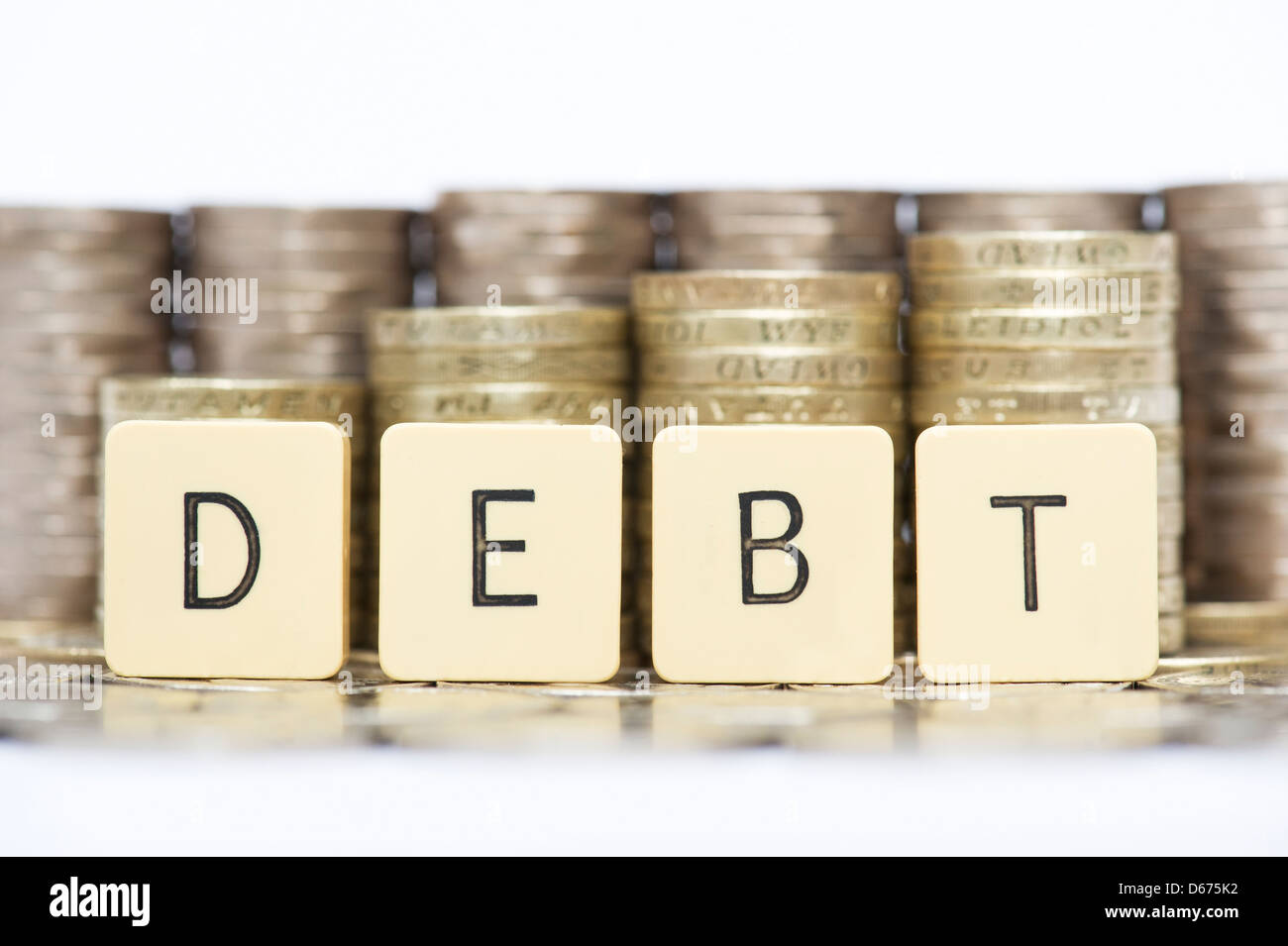 La parola debito nella parte anteriore delle pile di inglese venti pence e una libbra di monete Foto Stock