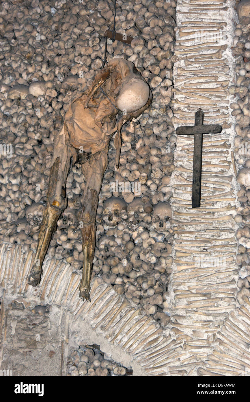 Evora, Portogallo. Scheletro da appendere alla parete nella Capela dos Ossos o Cappella delle Ossa. Foto Stock