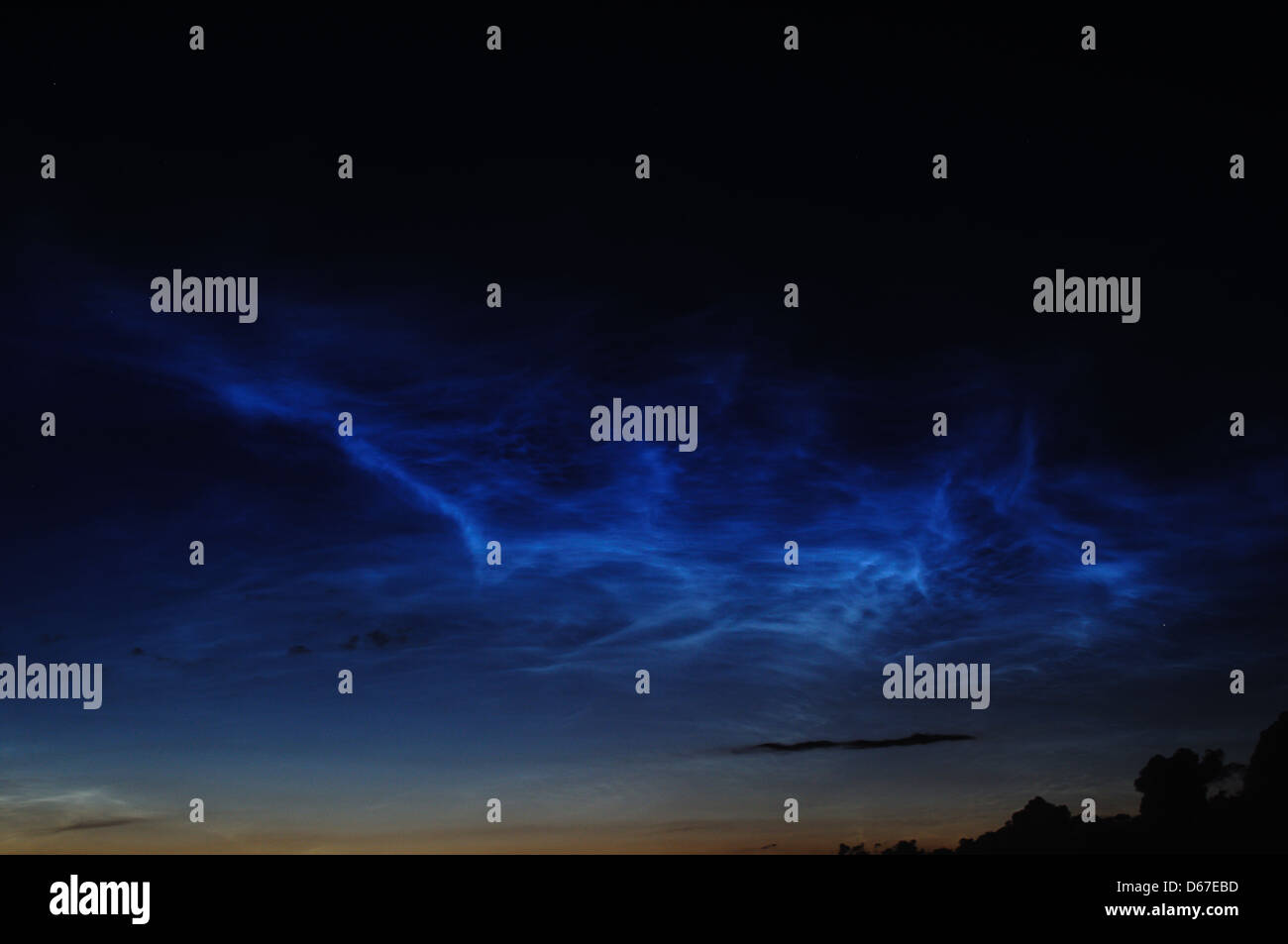 L'immagine mostra una fotografia digitale del cielo notturno, scattata con una Nikon D5100. Il cielo è pieno di nuvole e illuminato dalle luci della città, creando un contrasto tra le luci naturali e artificiali del paesaggio notturno. Foto Stock