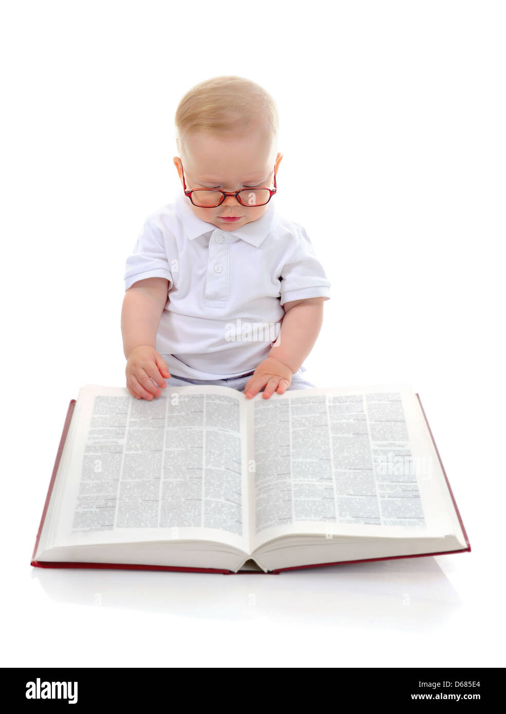Little Boy legge un libro di grandi dimensioni Foto Stock