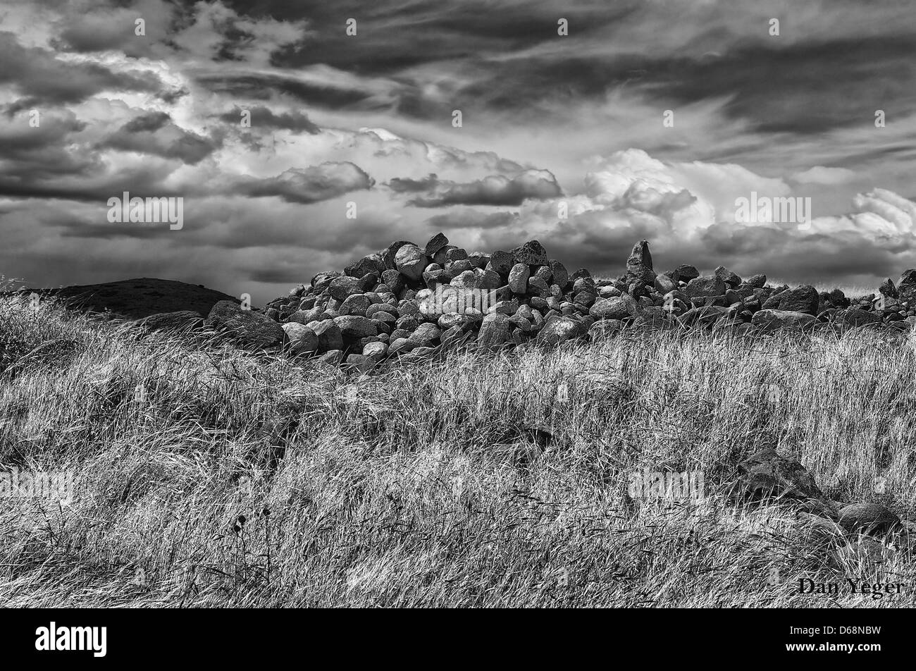 Manipolati digitalmente immagine di pietre in un campo con drammatica sky Foto Stock