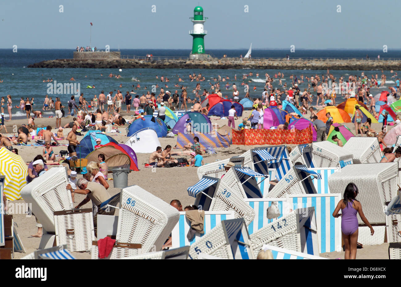 Numerosi vacanzieri godere di una giornata di sole in spiaggia in Warnemuende, Germania, 23 luglio 2012. Dopo settimane di rosso e pioggia di estate ha ora preso in consegna e il clima soleggiato attrae visitatori alle spiagge. Foto: BERND WUESTNECK Foto Stock