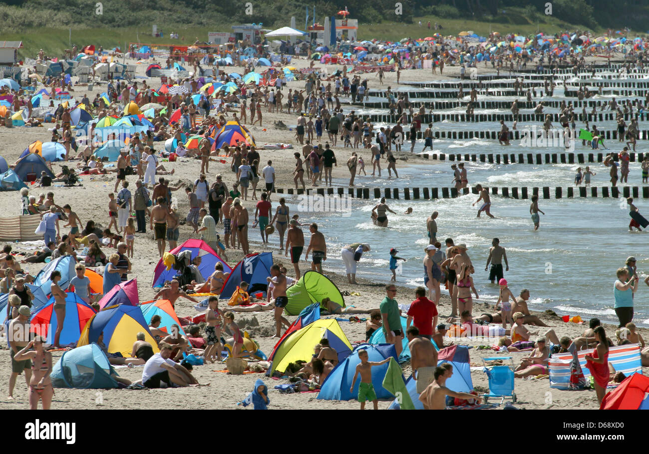 Numerosi vacanzieri godere di una giornata di sole in spiaggia in Warnemuende, Germania, 23 luglio 2012. Dopo settimane di rosso e pioggia di estate ha ora preso in consegna e il clima soleggiato attrae visitatori alle spiagge. Foto: BERND WUESTNECK Foto Stock