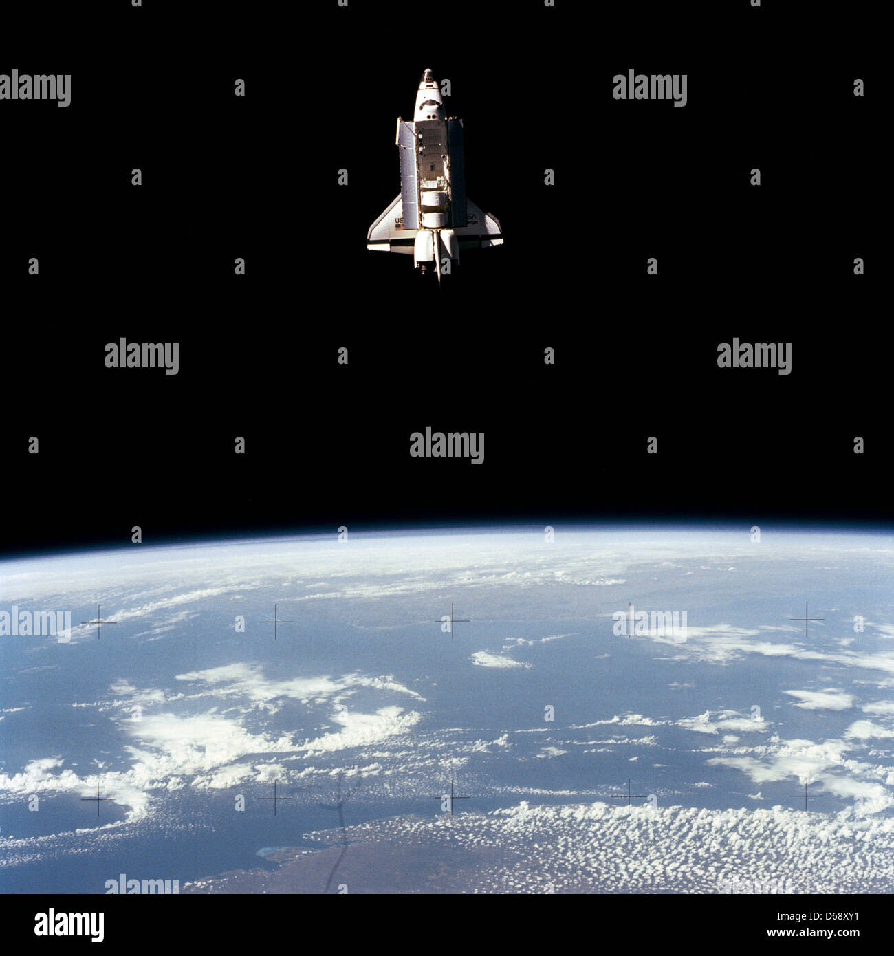 La terra-orbiting space shuttle Challenger al di là della Terra orizzonte è stata catturata da un 70mm Fotocamera a bordo senza equipaggio, liberi di volare Pallet Navetta via Satellite (ZPS-01) durante il volo occupato il giorno 5 di STS-7 missione in un luogo sconosciuto, 22 giugno 1983. Visibile nella stiva di cargo sono le basi di protezione per ora sgomberato Telesat Anik C-2 e Palapa B satelliti per le comunicazioni Foto Stock