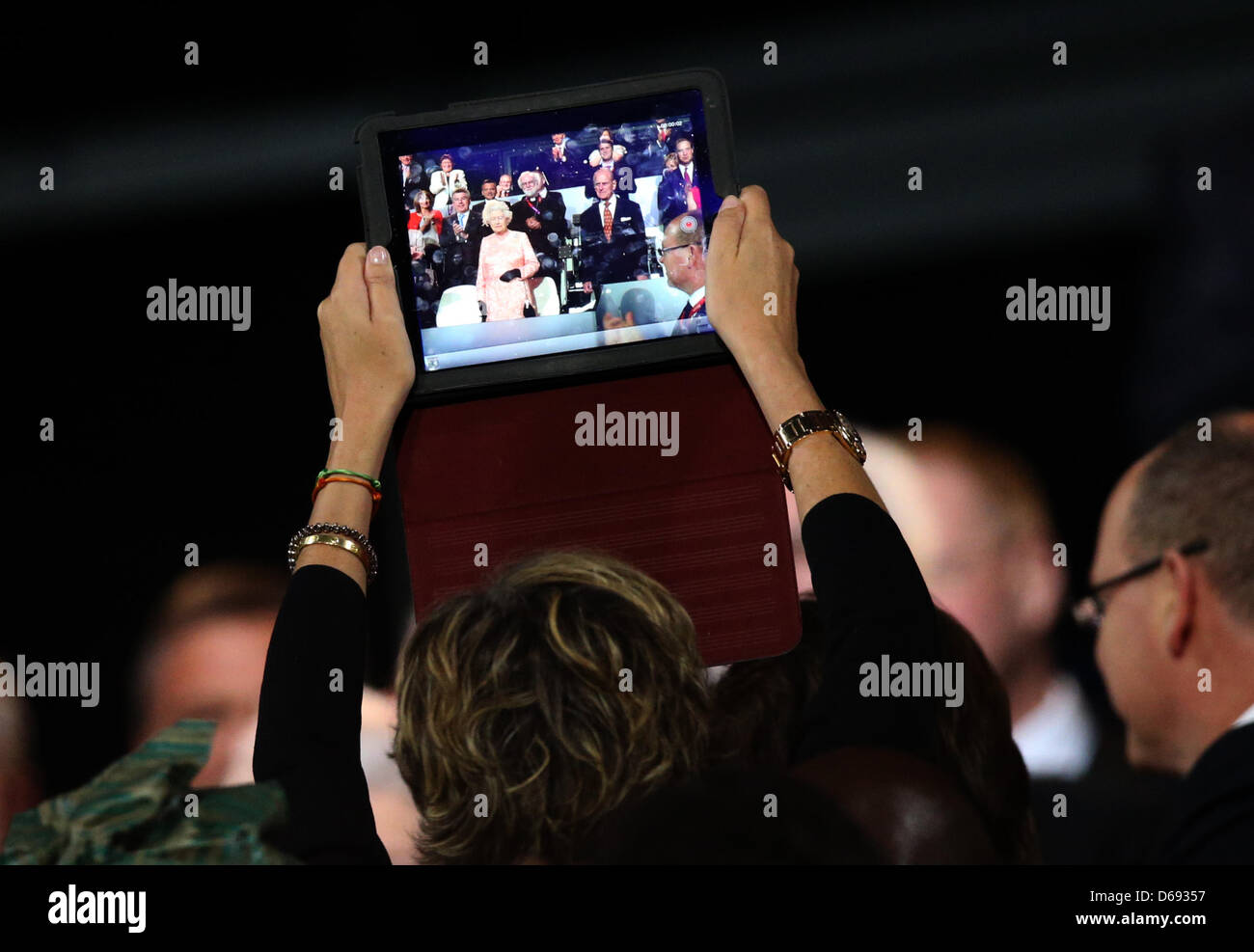 Un film dello spettatore la Regina Elisabetta II con un computer tablet durante la cerimonia di apertura del London 2012 Giochi Olimpici di Londra, Gran Bretagna, 27 luglio 2012. Il 2012 Giochi Olimpici Estivi si terrà a Londra dal 27 luglio al 12 agosto 2012. Foto: Christian Charisius dpa +++(c) dpa - Bildfunk+++ Foto Stock