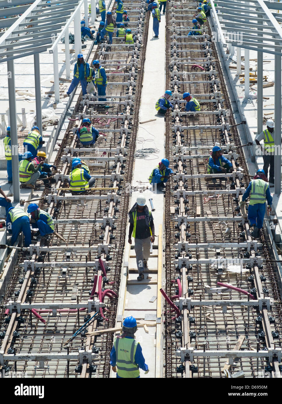 Lavoratori edili la posa di binari ferroviari per nuovo Al Sufouh tram in Dubai Emirati Arabi Uniti Foto Stock