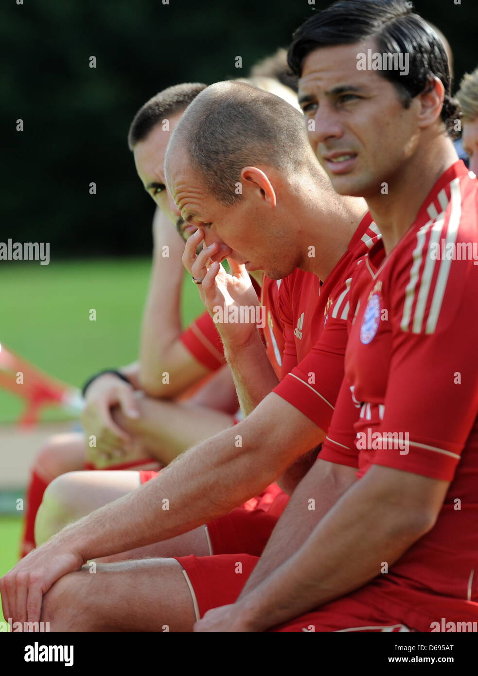 Der Spieler vom Bundesligisten FC Bayern München, Arjen Robben (M) fasst sich am Montag (30.07.2012) am Trainingsgelände an der Säbener Straße in München (Alta Baviera) beim offiziellen Fototermin des Vereins für die Saison 2012-13 ans Auge, während sein Teamkollege Claudio Pizarro (r) neben ihm sitzt. Foto: Tobias Hase dpa/lby Foto Stock