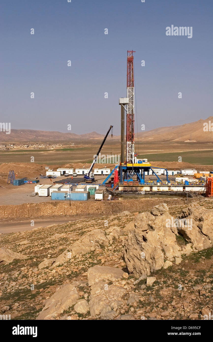 Olio e gas esplorazione onshore rig sito nella valle con montagne all orizzonte. Il Kurdistan iracheno, Iraq settentrionale Foto Stock