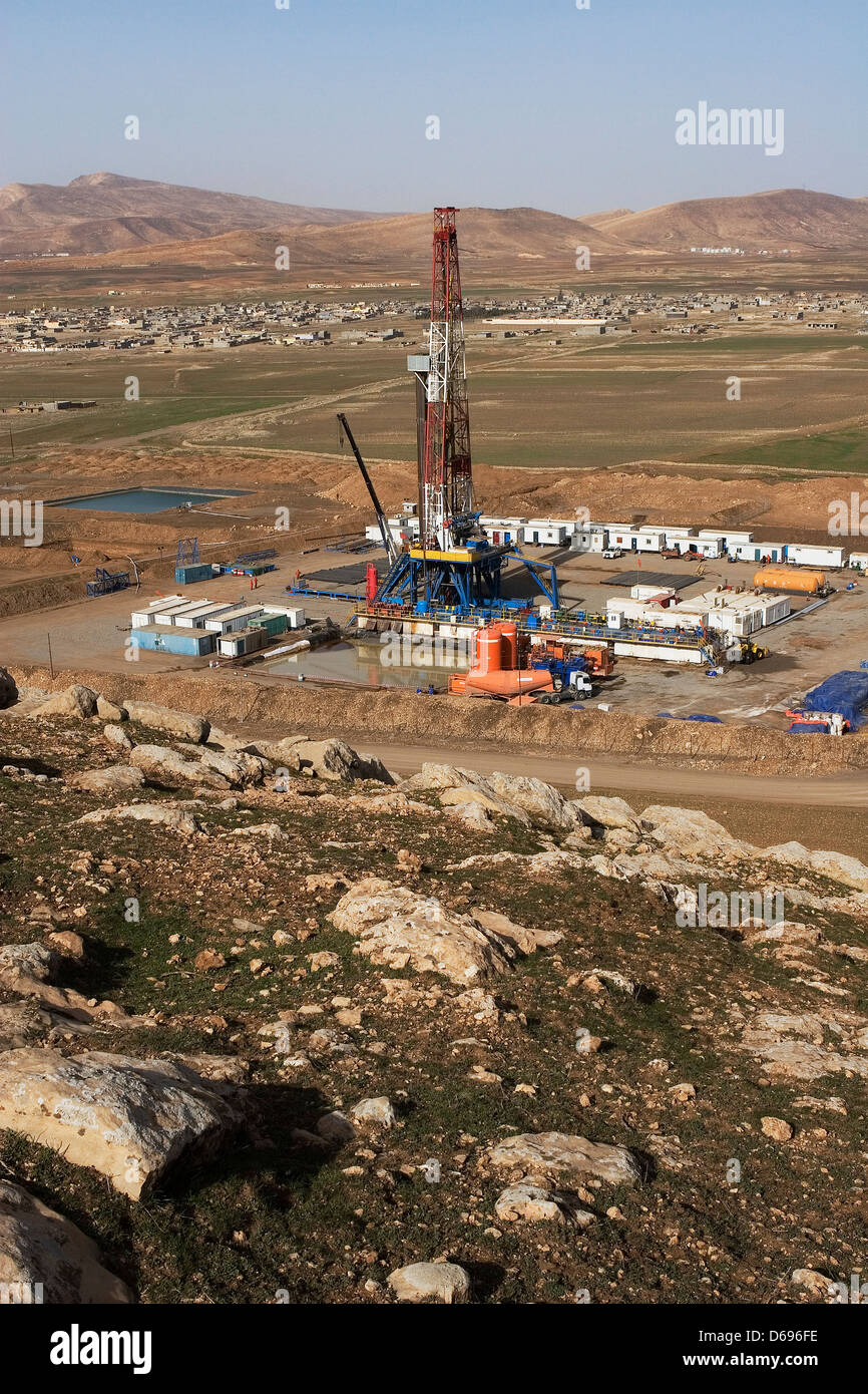 Olio e gas esplorazione onshore rig in valle con montagne all orizzonte. Il Kurdistan iracheno, Iraq settentrionale Foto Stock
