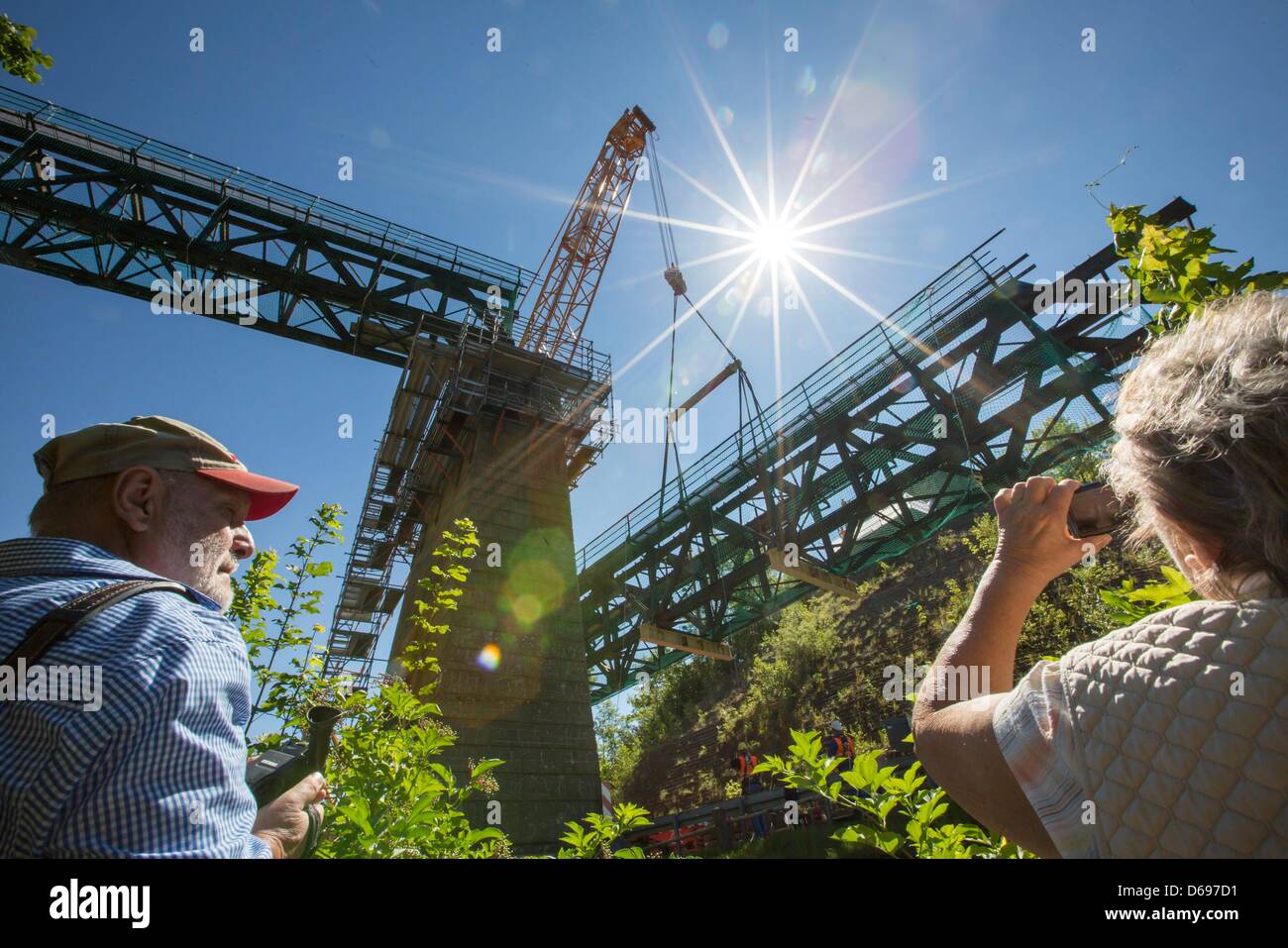 I visitatori osservano una grande gru di sollevamento 80 t-parte del viadotto ferroviario in Angelroda, Germania, 28 giugno 2012. È il primo di tre pezzi del 133 anno vecchio stell costruzione sulla linea Plaue-Ilmenau che viene ad essere completamente rinnovato. Azienda ferroviaria tedesca Deutsche Bahn investirà 13 milioni di euro nella ristrutturazione di un km 19 sezione. Foto: Michael Reichel Foto Stock