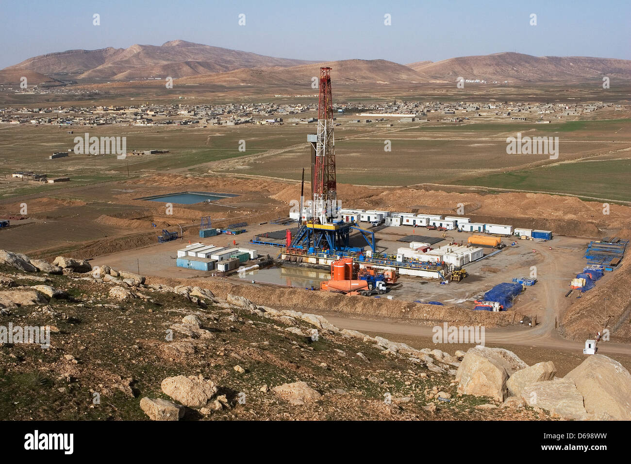 Olio e gas esplorazione onshore rig sito nella valle con montagne all orizzonte. Il Kurdistan iracheno, Iraq settentrionale Foto Stock