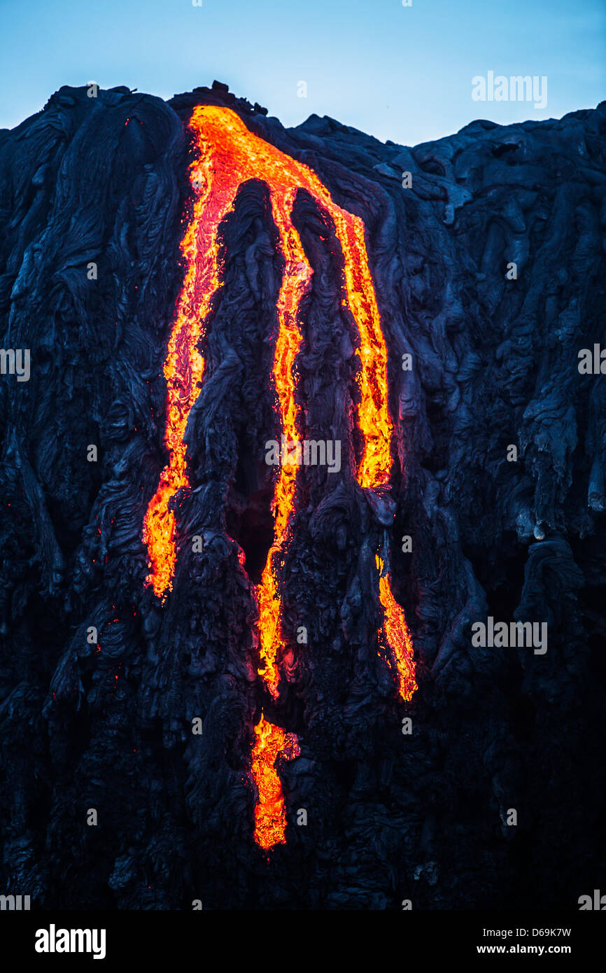 La lava scorre verso il basso scogliera rocciosa Foto Stock