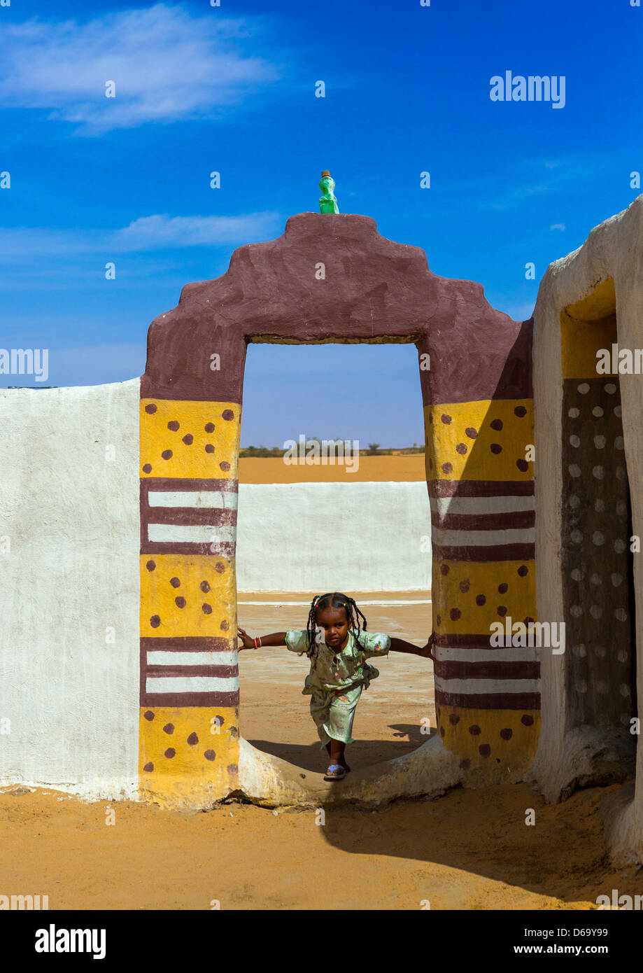 Bambina di fronte ad una tradizionale porta Nubiano, Old Dongola, Sudan Foto Stock