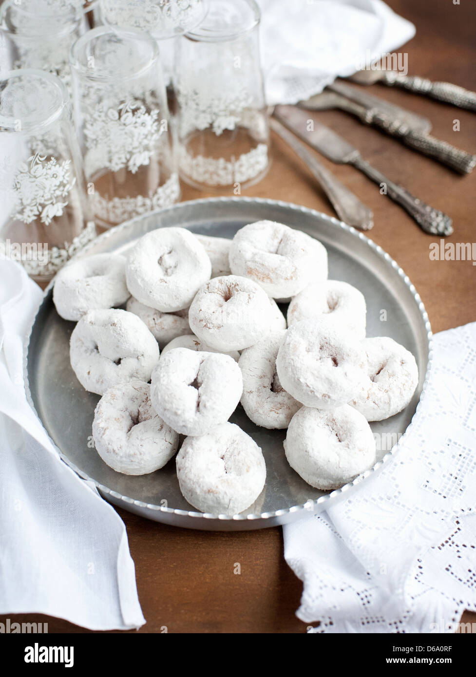 Vassoio di ciambelle con bicchieri di acqua Foto Stock