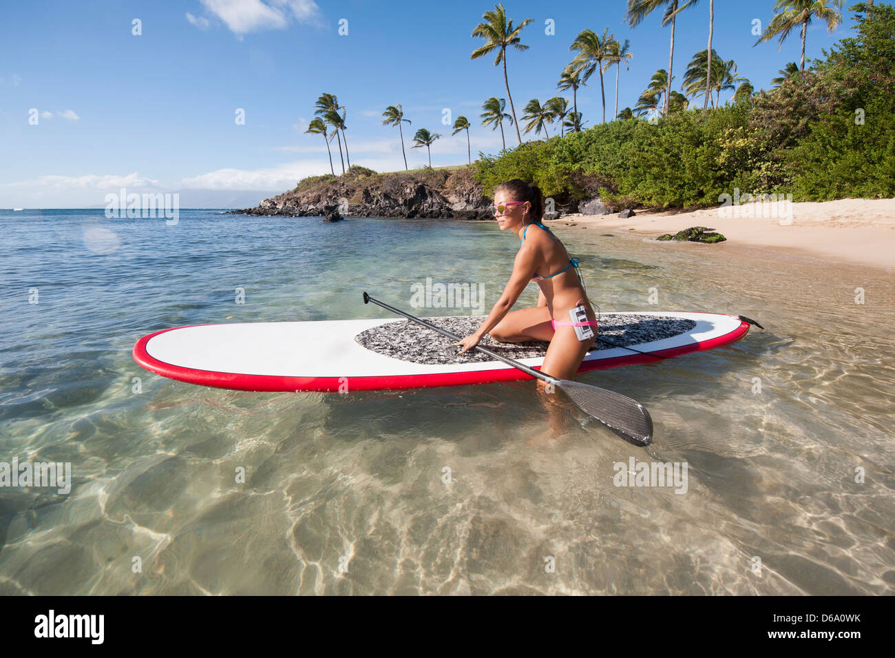 Donna paddleboarding su ocean Foto Stock