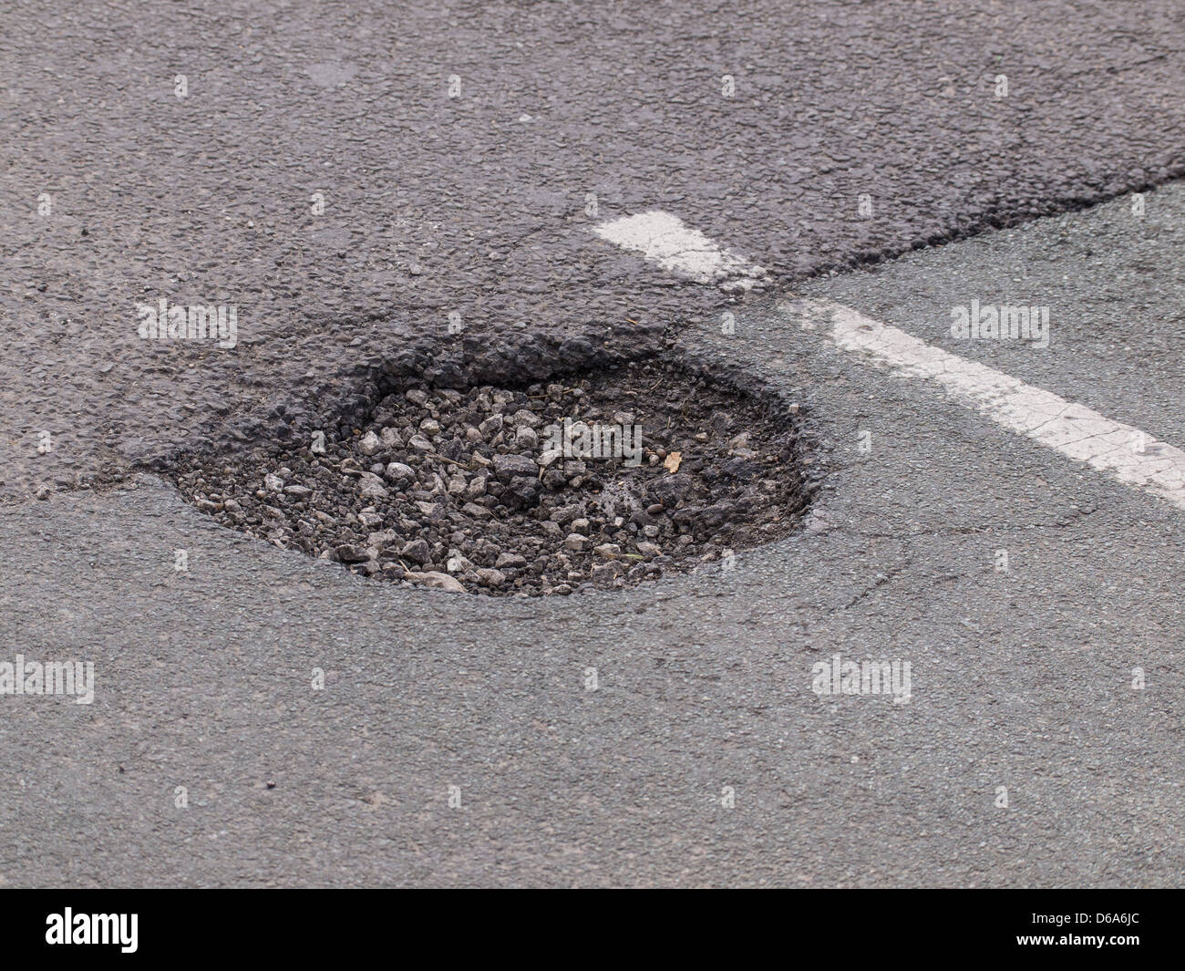 Grandi buche nella strada asfaltata dopo il brutto tempo Foto Stock