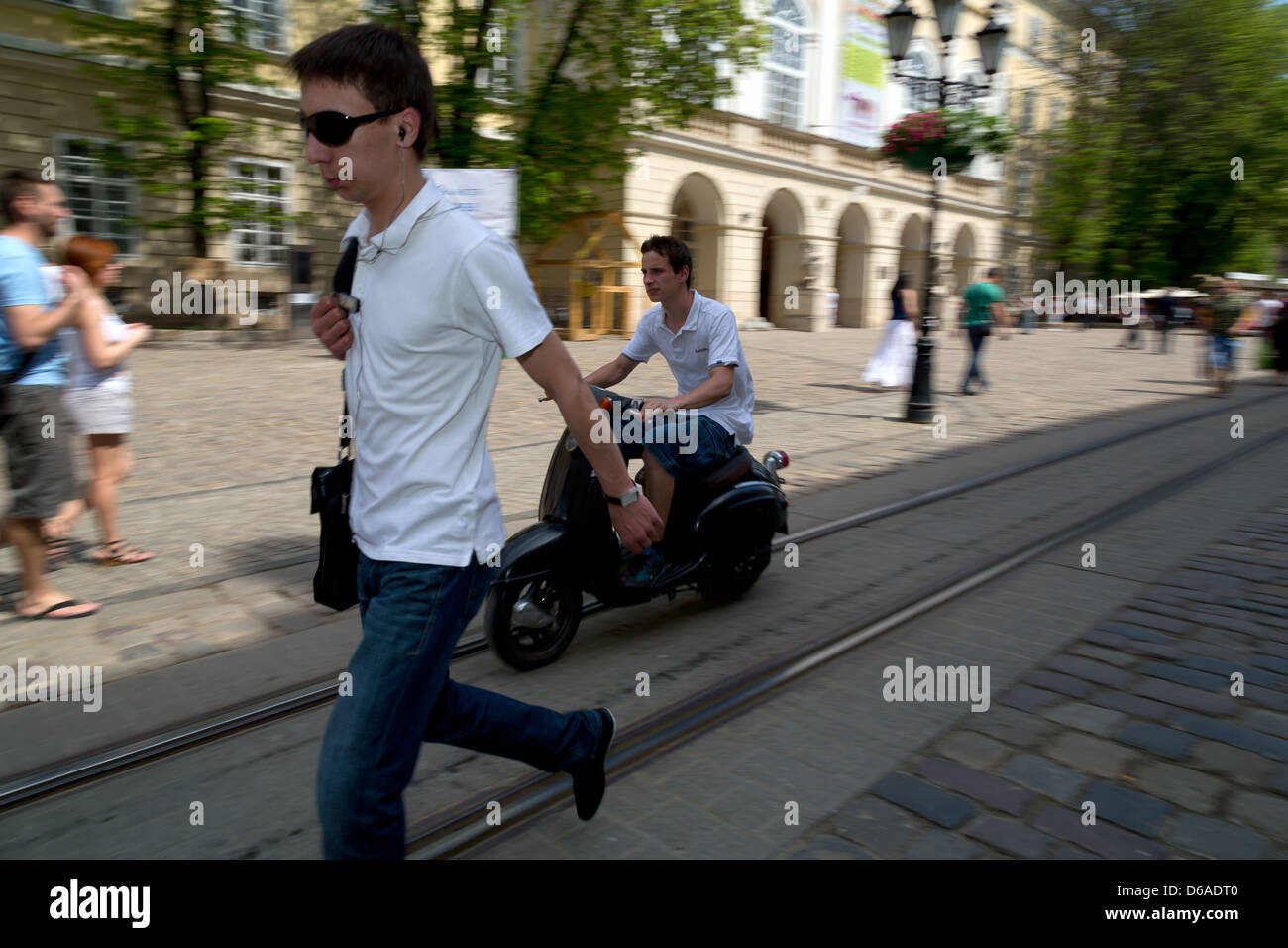 Lviv, Ucraina, pedoni e scooteristi nella città vecchia Foto Stock