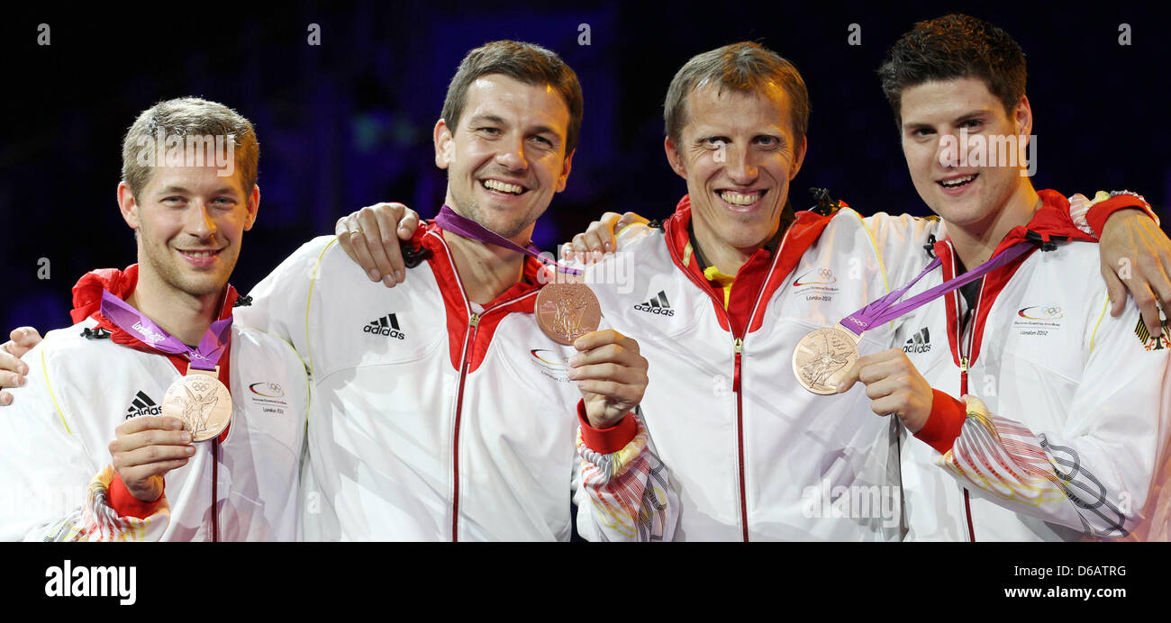 La Germania (L-R) Bastian Steger, Timo Boll, coach Joerg Rosskopf e Dimitrij Ovtcharov celebrano le loro medaglie di bronzo durante la premiazione per gli uomini del team tennis da tavolo in ExCeL Arena presso il London 2012 Giochi Olimpici di Londra, Gran Bretagna, 08 agosto 2012. Foto: Friso Gentsch dpa +++(c) dpa - Bildfunk+++ Foto Stock