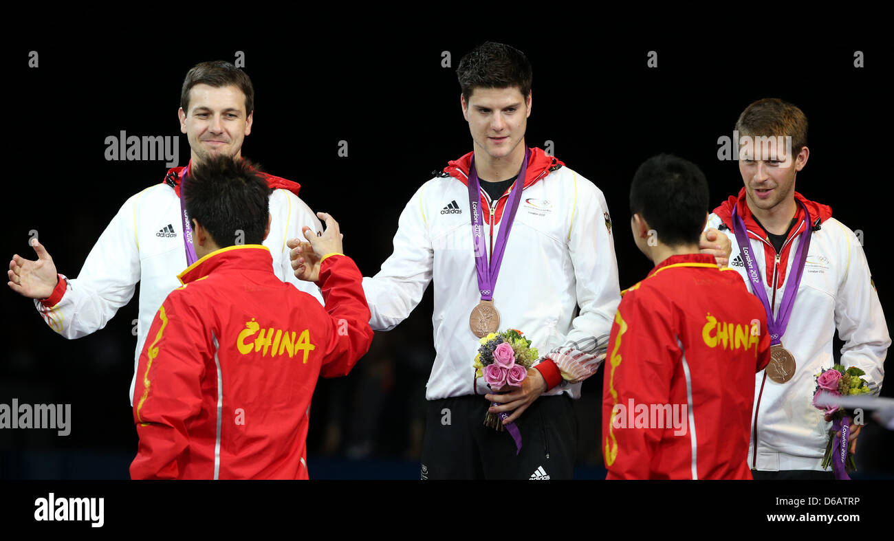 La Germania (L-R) Timo Boll, Dimitrij Ovtcharov e Bastian Steger celebrano le loro medaglie di bronzo durante la premiazione per gli uomini del team tennis da tavolo in ExCeL Arena presso il London 2012 Giochi Olimpici di Londra, Gran Bretagna, 08 agosto 2012. Foto: Friso Gentsch dpa +++(c) dpa - Bildfunk+++ Foto Stock