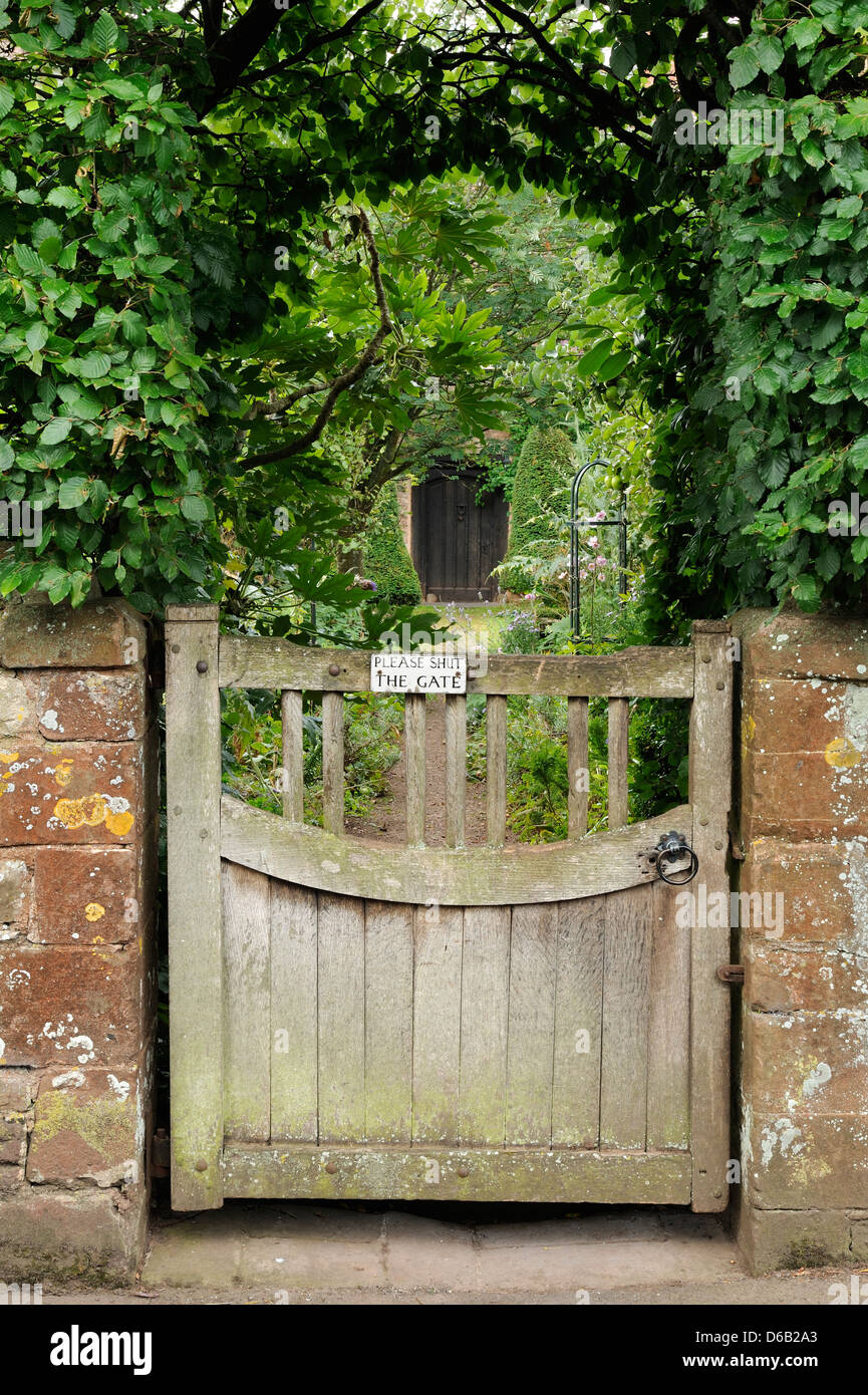 Un cancello che conduce a un pittoresco giardino tradizionale nel villaggio di Dunster, Somerset, Regno Unito. Foto Stock