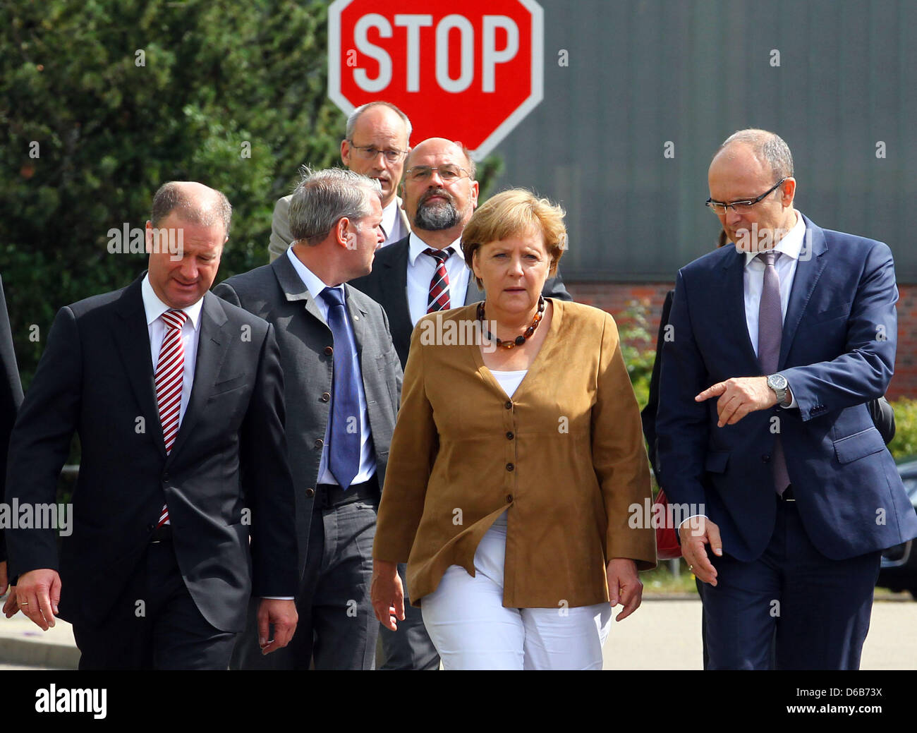 Il cancelliere tedesco Angela Merkel, Premier di Meclemburgo-pomerania Erwin Sellering (R) e Manager di P+S-Werften in Stralsund e Wolgast Ruediger Fuchs (L) dare una dichiarazione all'ingresso del cantiere Volksweft a Stralsund, Germania, 21 agosto 2012. Merkel ha preso parte a una riunione sul futuro della società di costruzione navale, dove i rappresentanti dei media non sono consentiti. Foto Stock