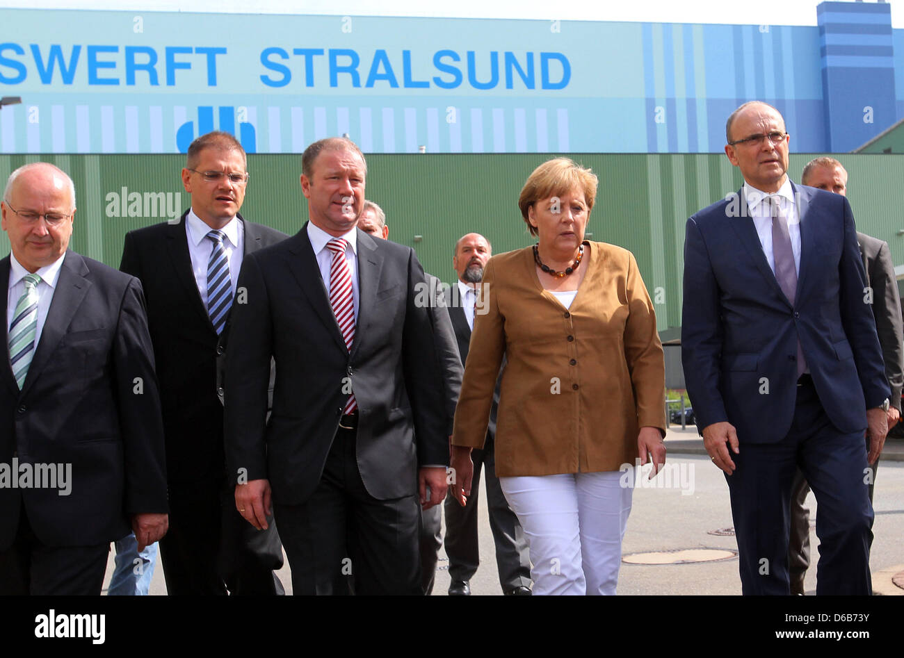 Il cancelliere tedesco Angela Merkel, Premier di Meclemburgo-pomerania Erwin Sellering (R) e Manager di P+S-Werften in Stralsund e Wolgast Ruediger Fuchs (2-L) dare una dichiarazione all'ingresso del cantiere Volksweft a Stralsund, Germania, 21 agosto 2012. Merkel ha preso parte a una riunione sul futuro della società di costruzione navale, dove i rappresentanti dei media non sono ammesse Foto Stock