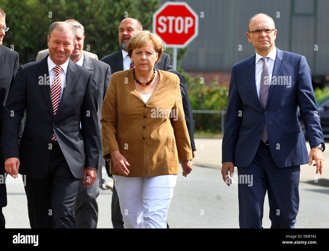 Il cancelliere tedesco Angela Merkel, Premier di Meclemburgo-pomerania Erwin Sellering (R) e Manager di P+S-Werften in Stralsund e Wolgast Ruediger Fuchs (L) dare una dichiarazione all'ingresso del cantiere Volksweft a Stralsund, Germania, 21 agosto 2012. Merkel ha preso parte a una riunione sul futuro della società di costruzione navale, dove i rappresentanti dei media non sono consentiti. Foto Stock
