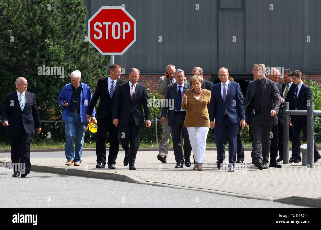 Il cancelliere tedesco Angela Merkel (C), Premier di Meclemburgo-pomerania Erwin Sellering (R di Merkel) e Manager di P+S-Werften in Stralsund e Wolgast Ruediger Fuchs (4-L) dare una dichiarazione all'ingresso del cantiere Volksweft a Stralsund, Germania, 21 agosto 2012. Merkel ha preso parte a una riunione sul futuro della società di costruzione navale, dove i rappresentanti dei media sono stati Foto Stock