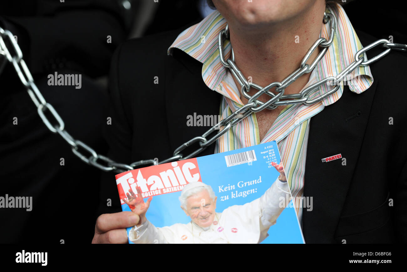 Un membro del comitato di redazione della rivista satirica Titanic indossa le catene attorno al suo collo nella parte anteriore della chiesa di San Michele (Michel) ad Amburgo, Germania, 30 agosto 2012. Somem redattori del Titanic simbolicamente incatenati da soli a Michel in segno di protesta contro una prova sulla controversa Titanic copertura che mostra il papa con una macchia gialla nella zona del cavallo. Foto: DANIEL REINHA Foto Stock
