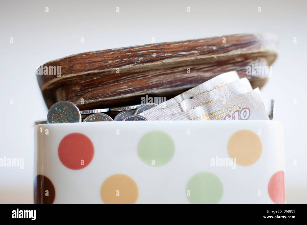 Vaso pieno di denaro sulla scrivania Foto Stock